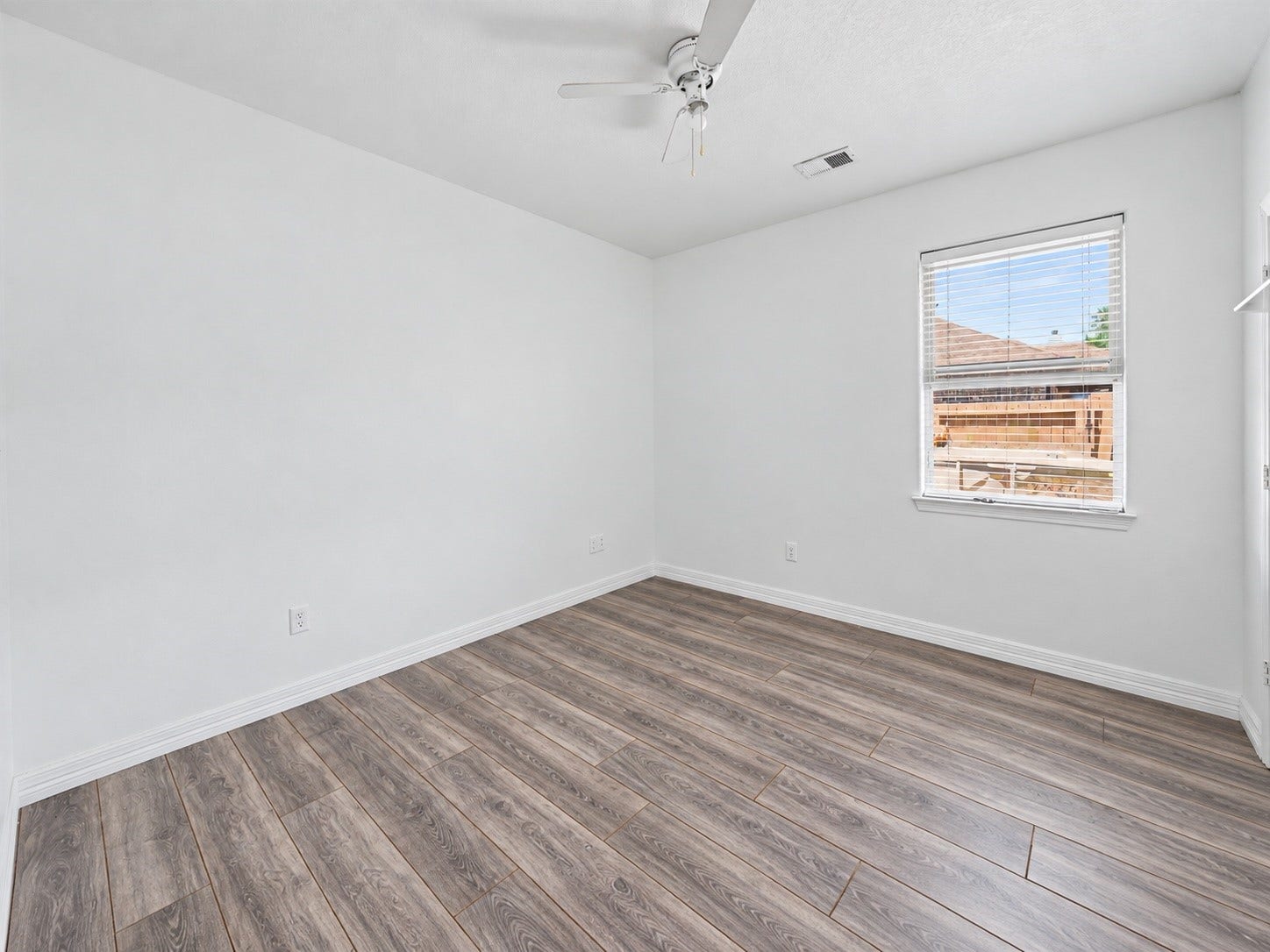 Secondary bedroom with wood look tile flooring, ceiling fan, and natural light. ***Digitally enhanced guest BR images - floors need to be finished