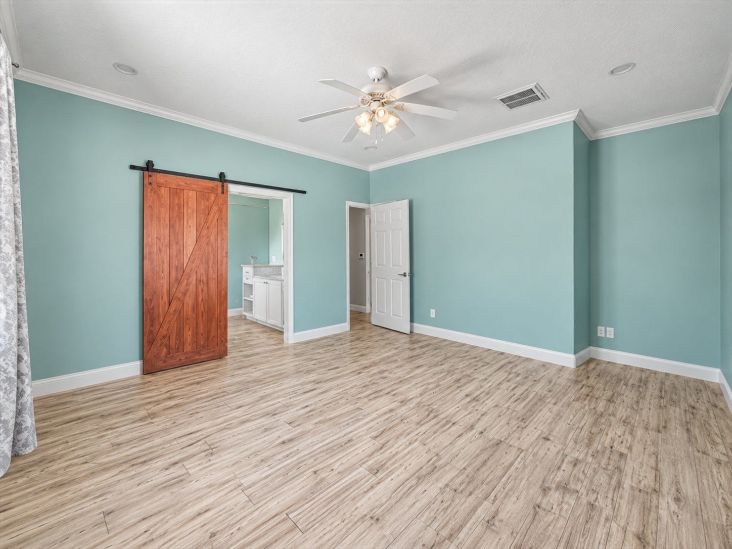Primary bedroom features a barn-style sliding door leading into the private en-suite bath