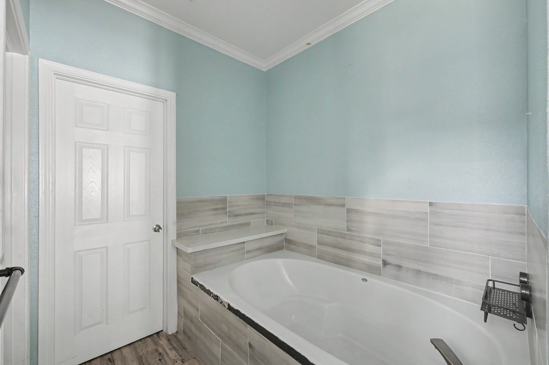 Relaxing soaking tub with tiles surround and convenient built-in ledge for bath essentials.
