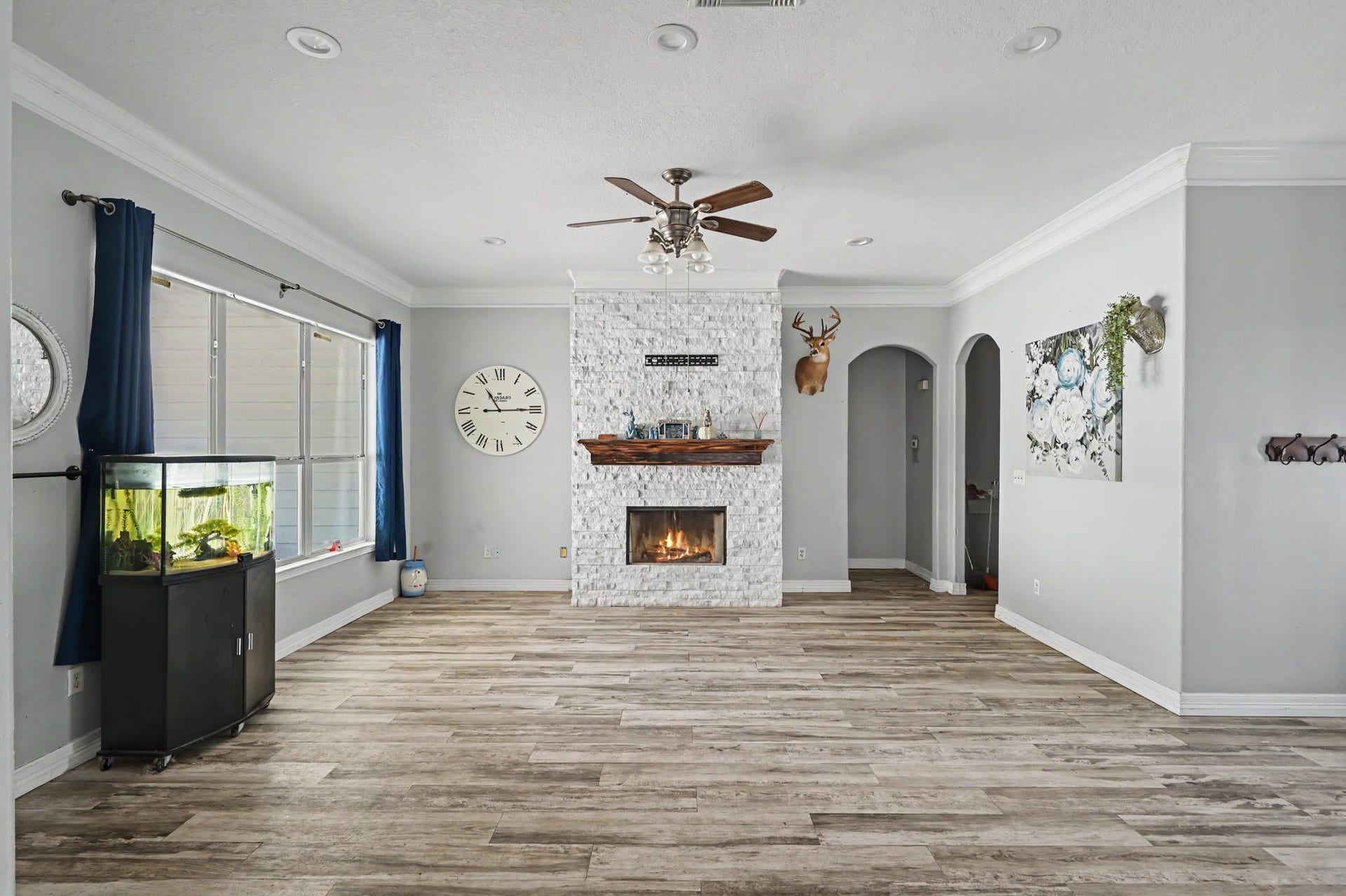 Spacious Living area with abundant natural light, durable flooring and an impressive stone fireplace focal point.