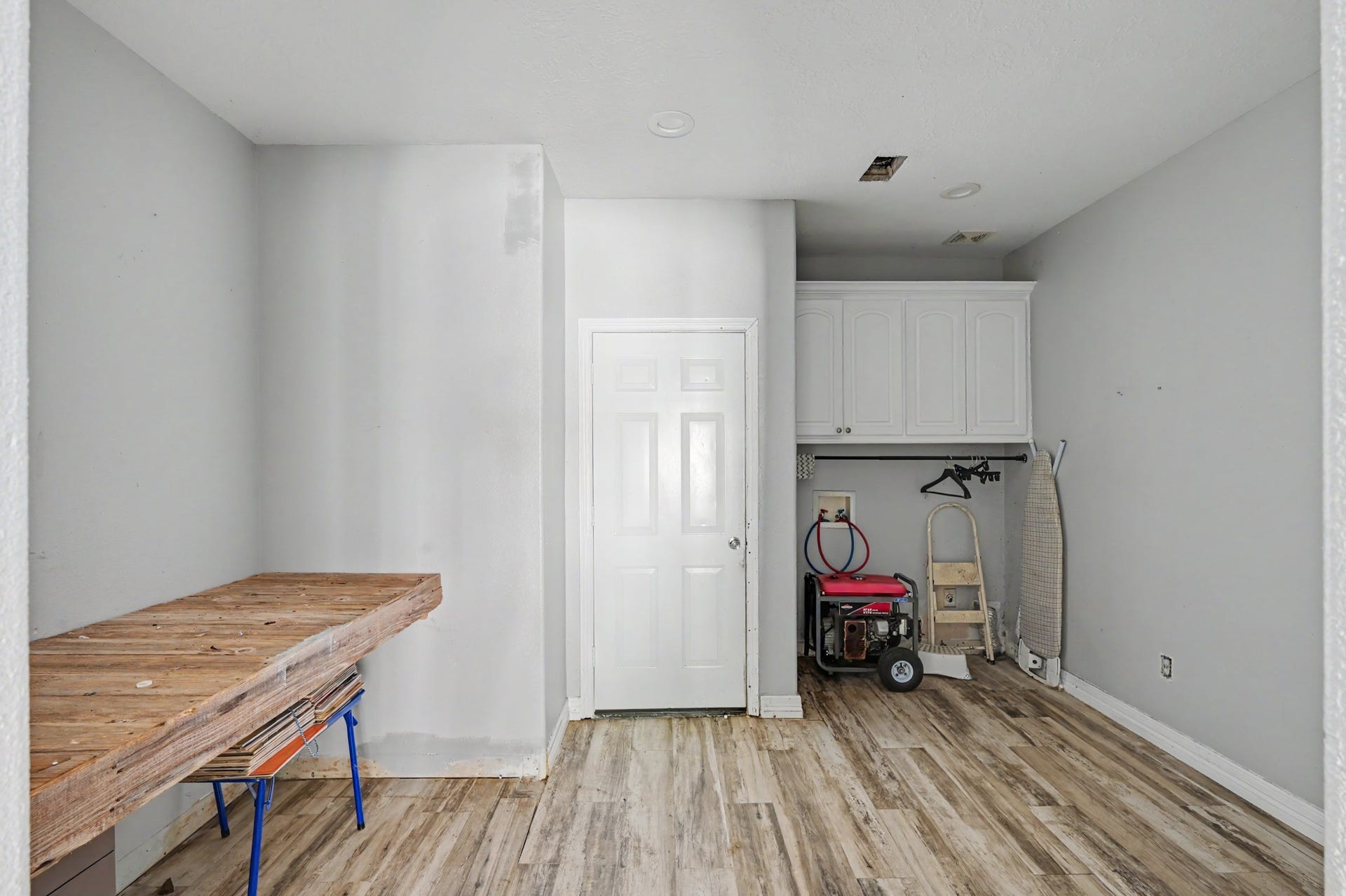 Oversized laundry and mud room with built-in cabinetry, utility workspace, and abundant room for storage and organization.