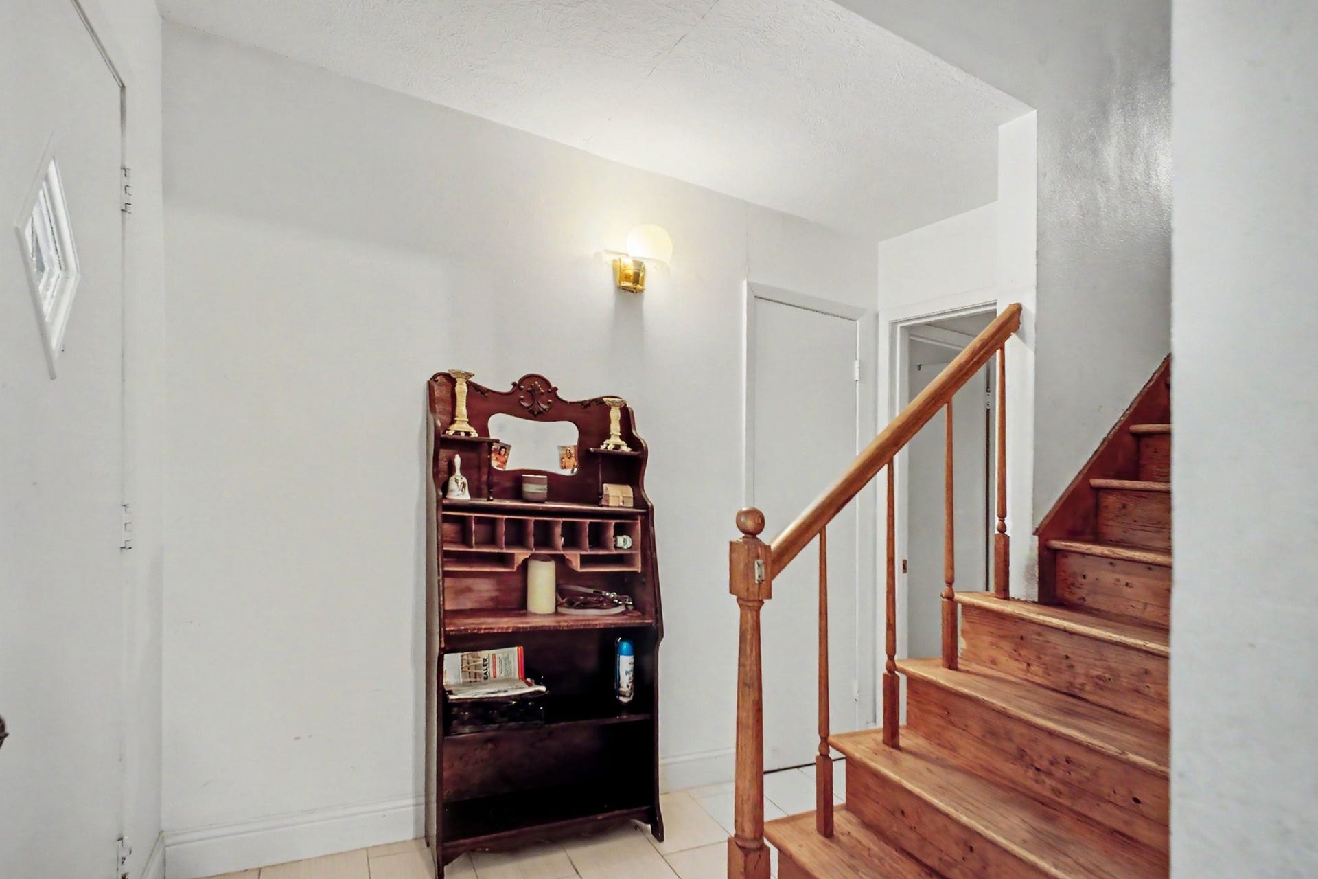 Interior transition area featuring a sturdy wooden staircase leading to upper levels.