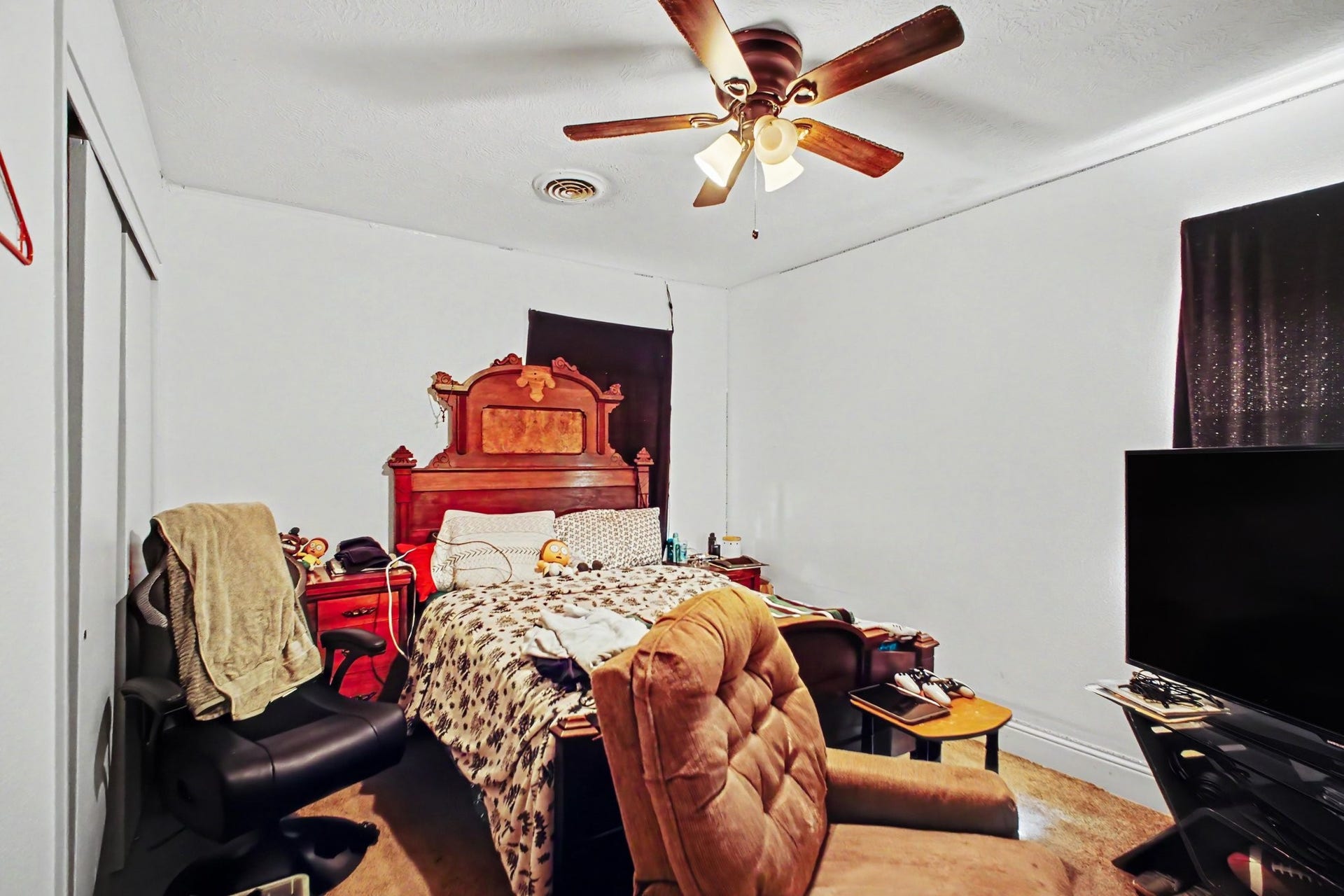 Spacious bedroom or secondary lounge space featuring large furnishings and warm interior decor.
