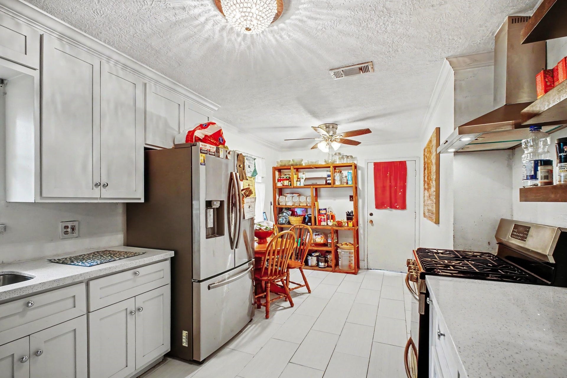 Bright, functional kitchen featuring white cabinetry, modern appliances, and seamless access to dining.