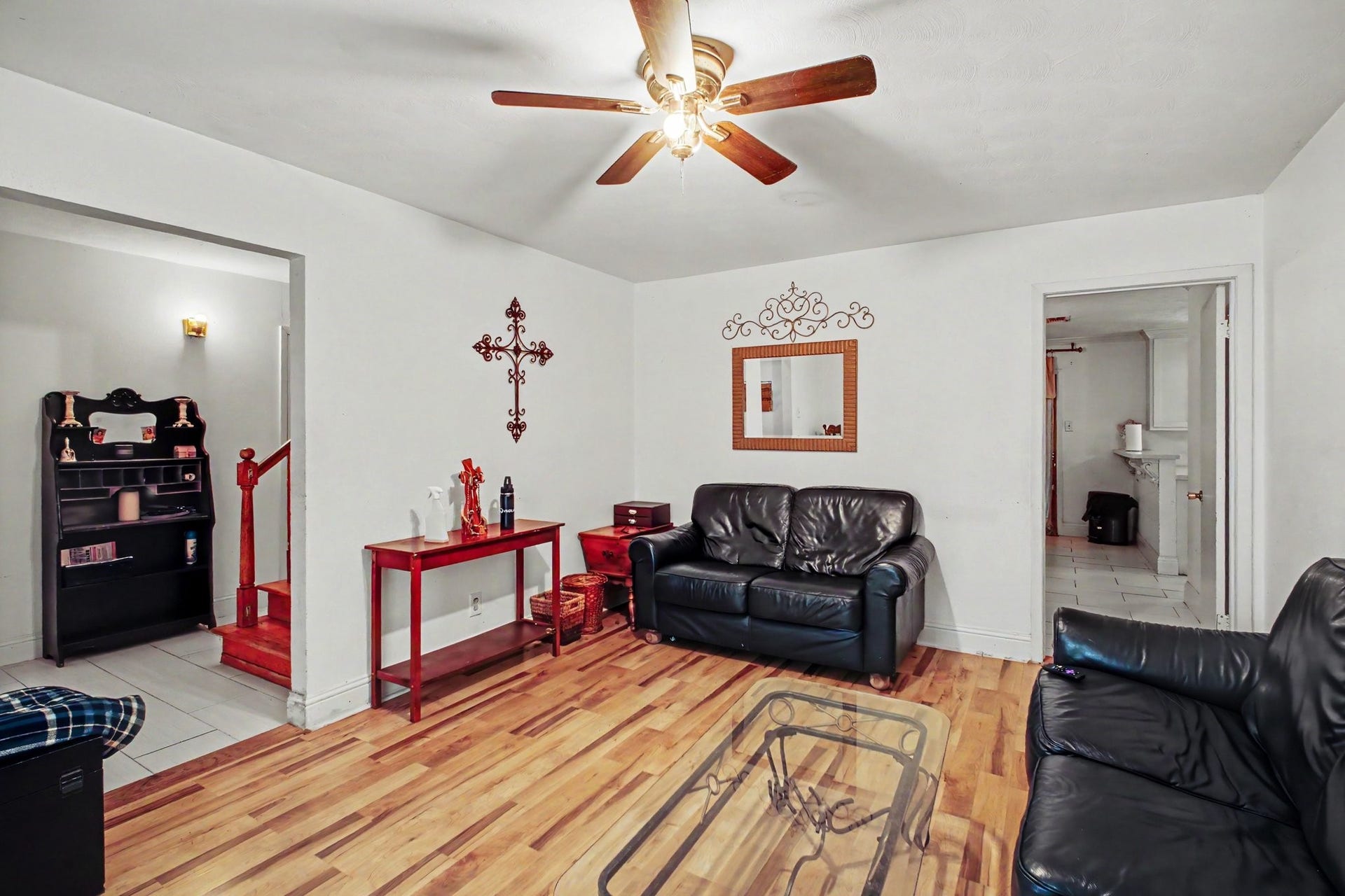 Alternate angle of the living space highlighting the open layout, natural light, and ceiling fan.