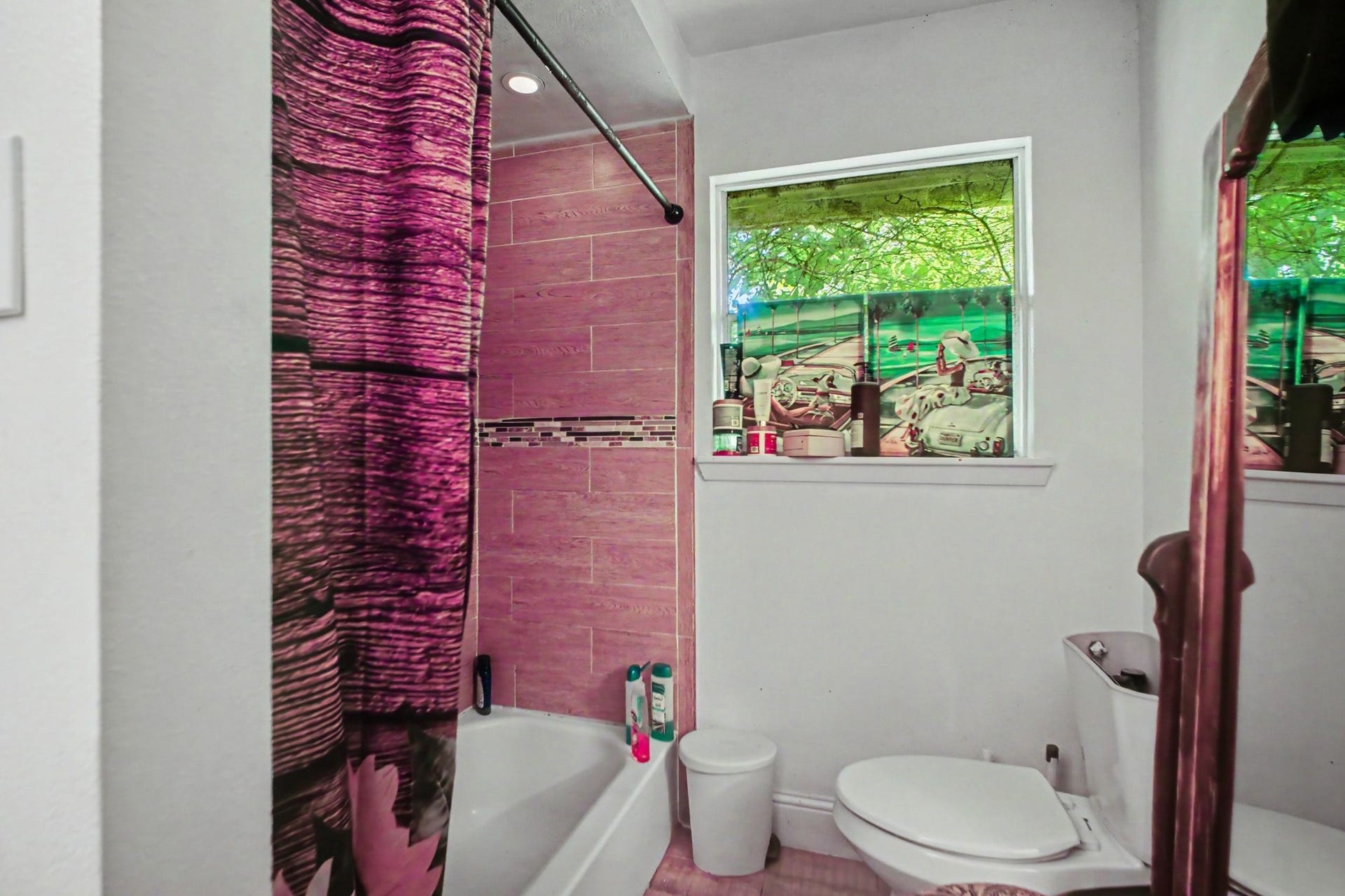 Full bathroom featuring a vibrant bathtub alcove with patterned walls and modern fixtures.