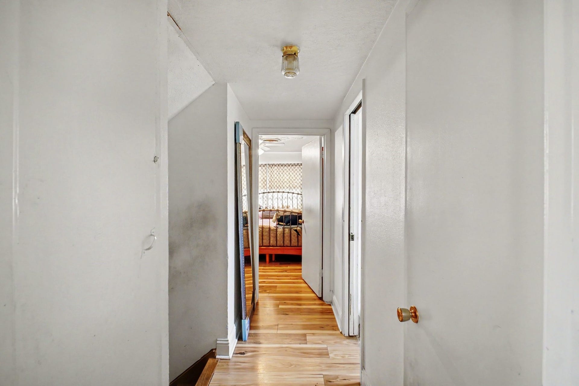 Straight corridor view connecting multiple rooms with clean white finishes and flush lighting.