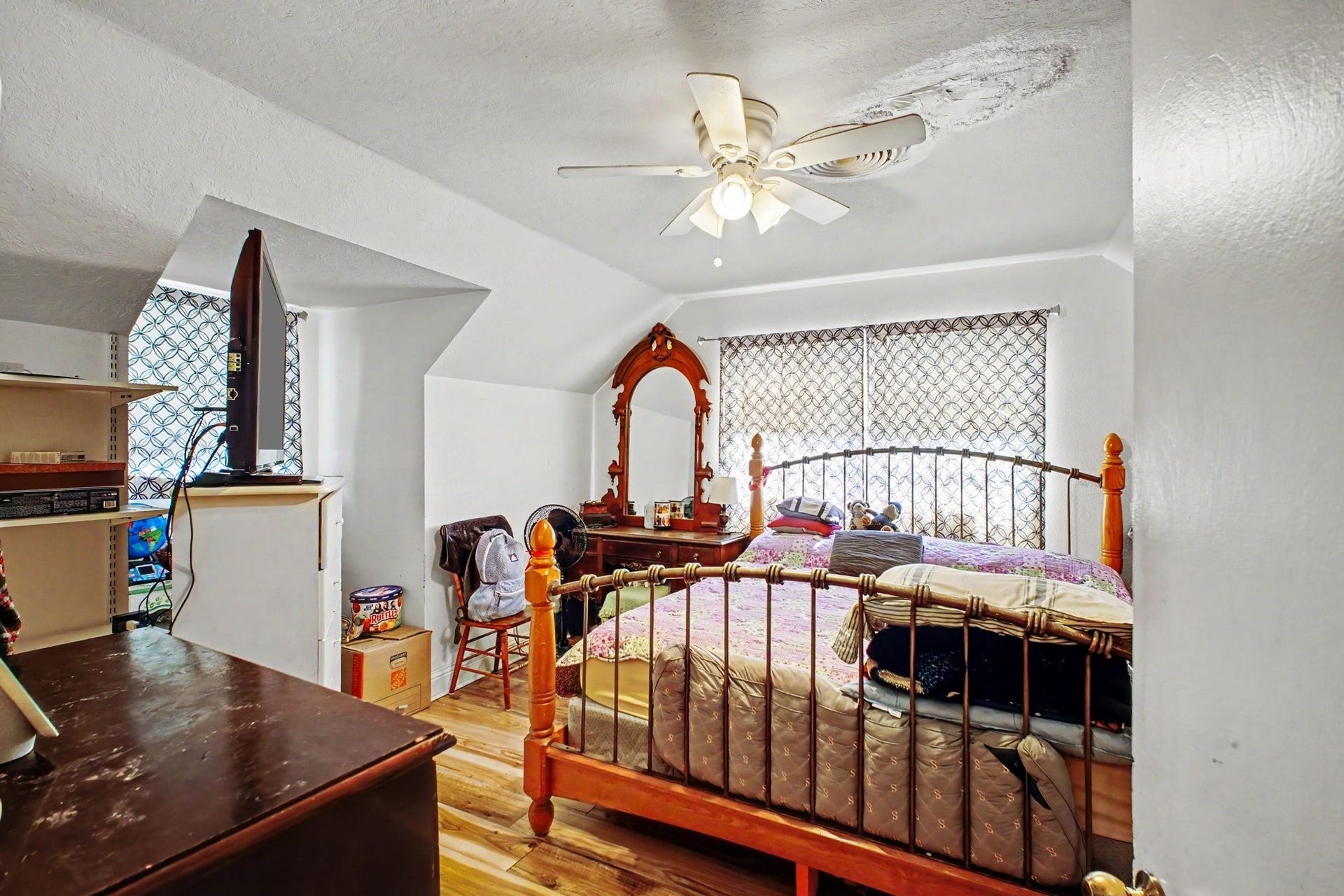 Cozy bedroom retreat featuring traditional wooden bedroom sets and natural sunlight.