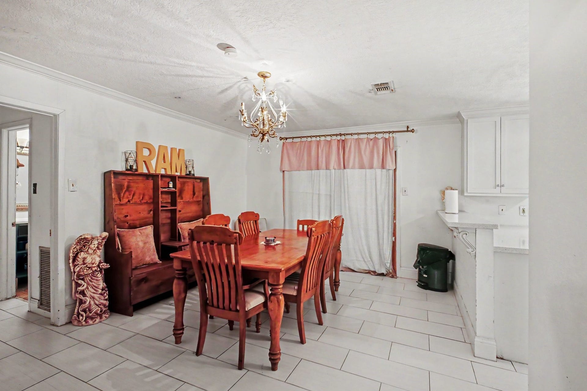 Spacious formal dining room featuring a classic wood dining table and clean tile flooring.