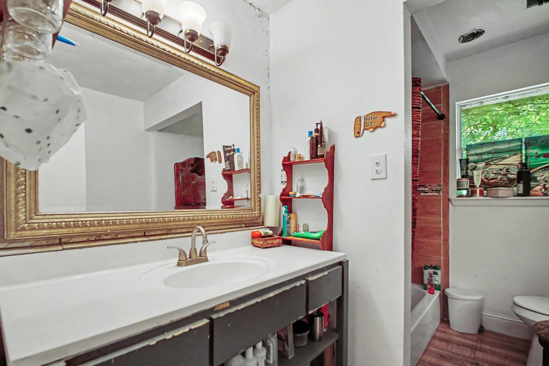 Expansive bathroom vanity area boasting a wide mirror, large countertop, and modern lighting.