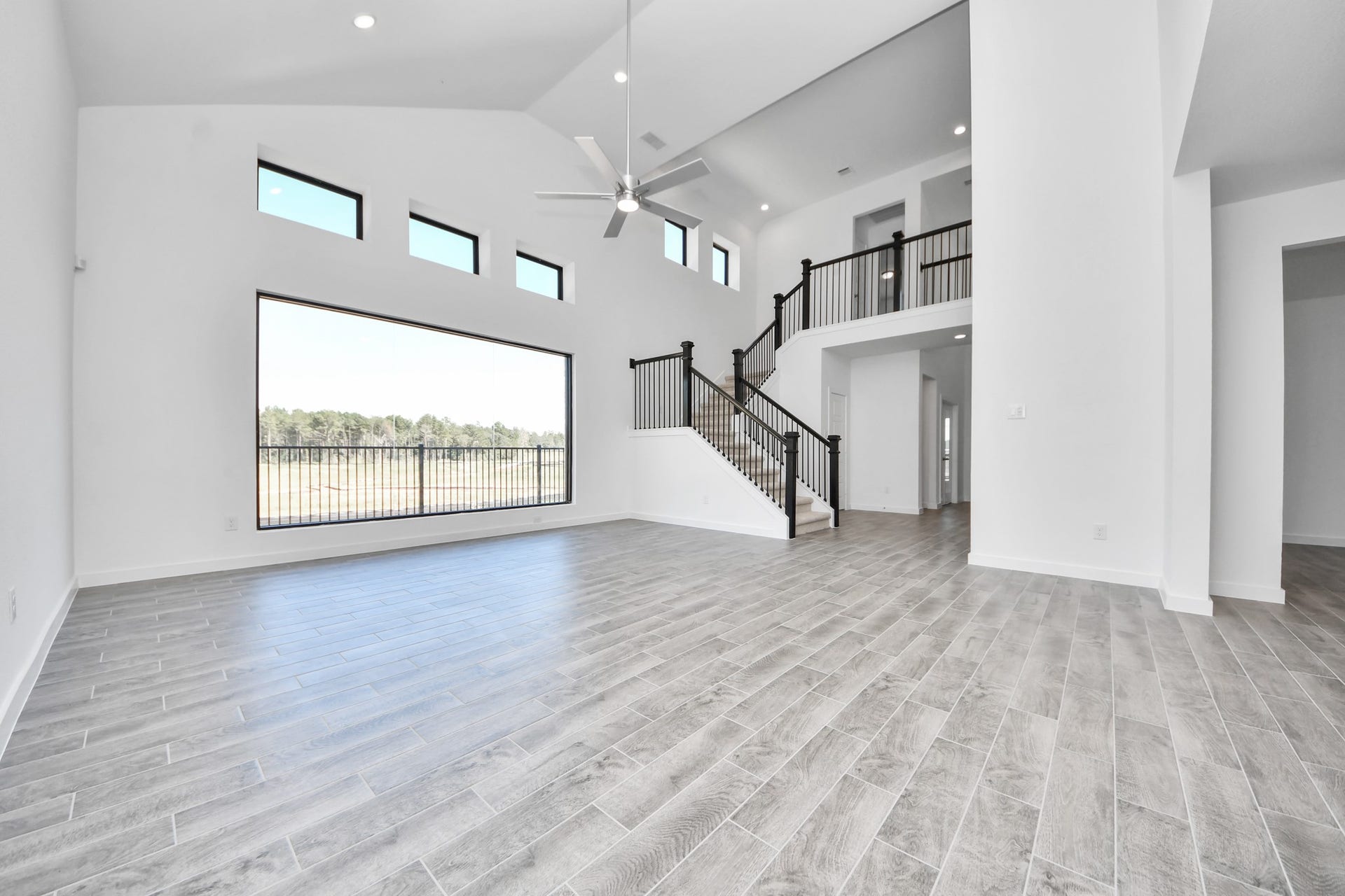 Gather the family and guests together in your lovely living room! Featuring soaring high ceilings, recessed lighting, ceiling fan, custom paint, gorgeous floors, and large windows that provide plenty of natural lighting throughout the day.