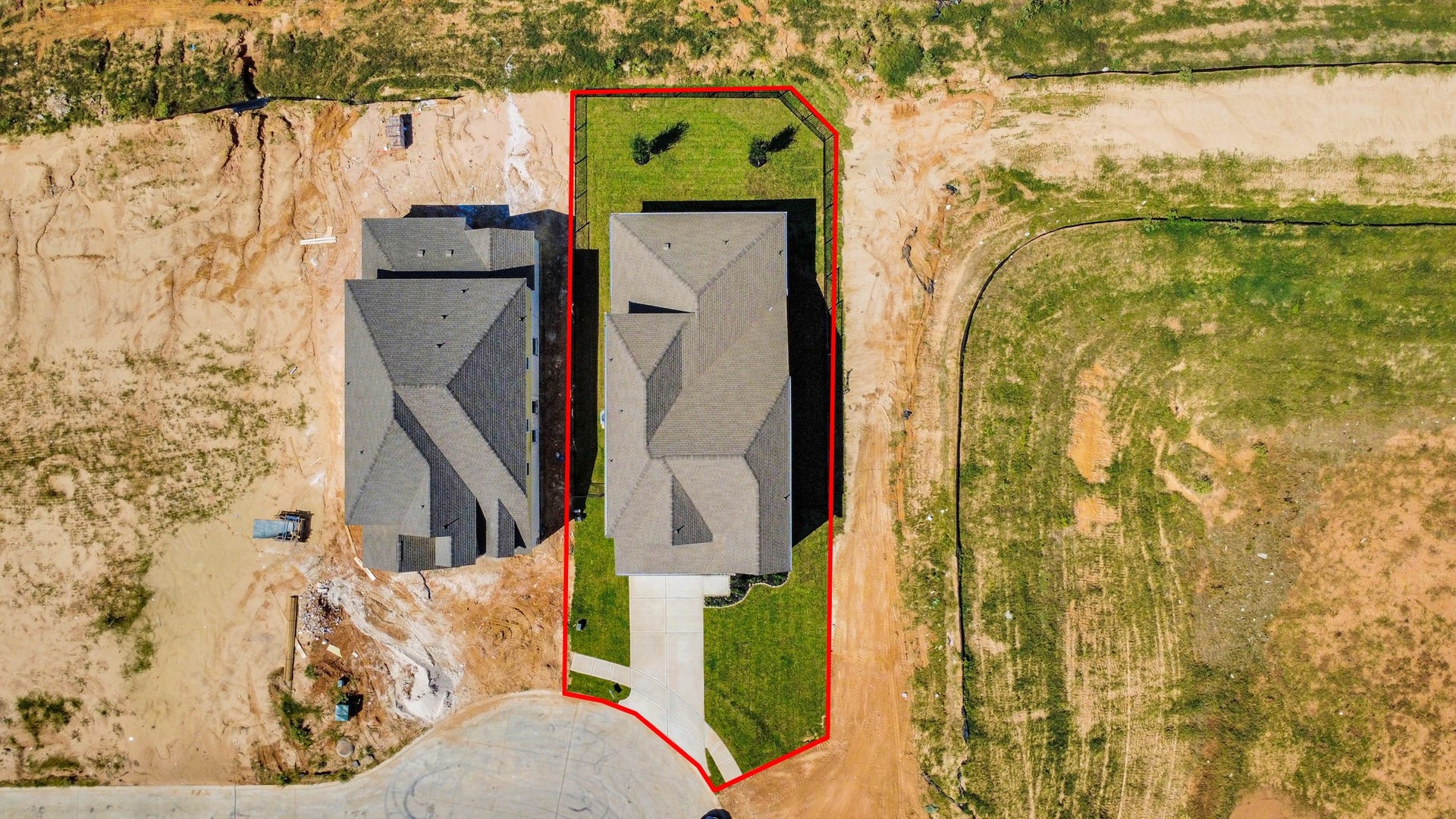 An aerial view of a spacious subdivision lot, highlighting a well-maintained yard and a fully fenced perimeter, offering both privacy and expansive outdoor space.