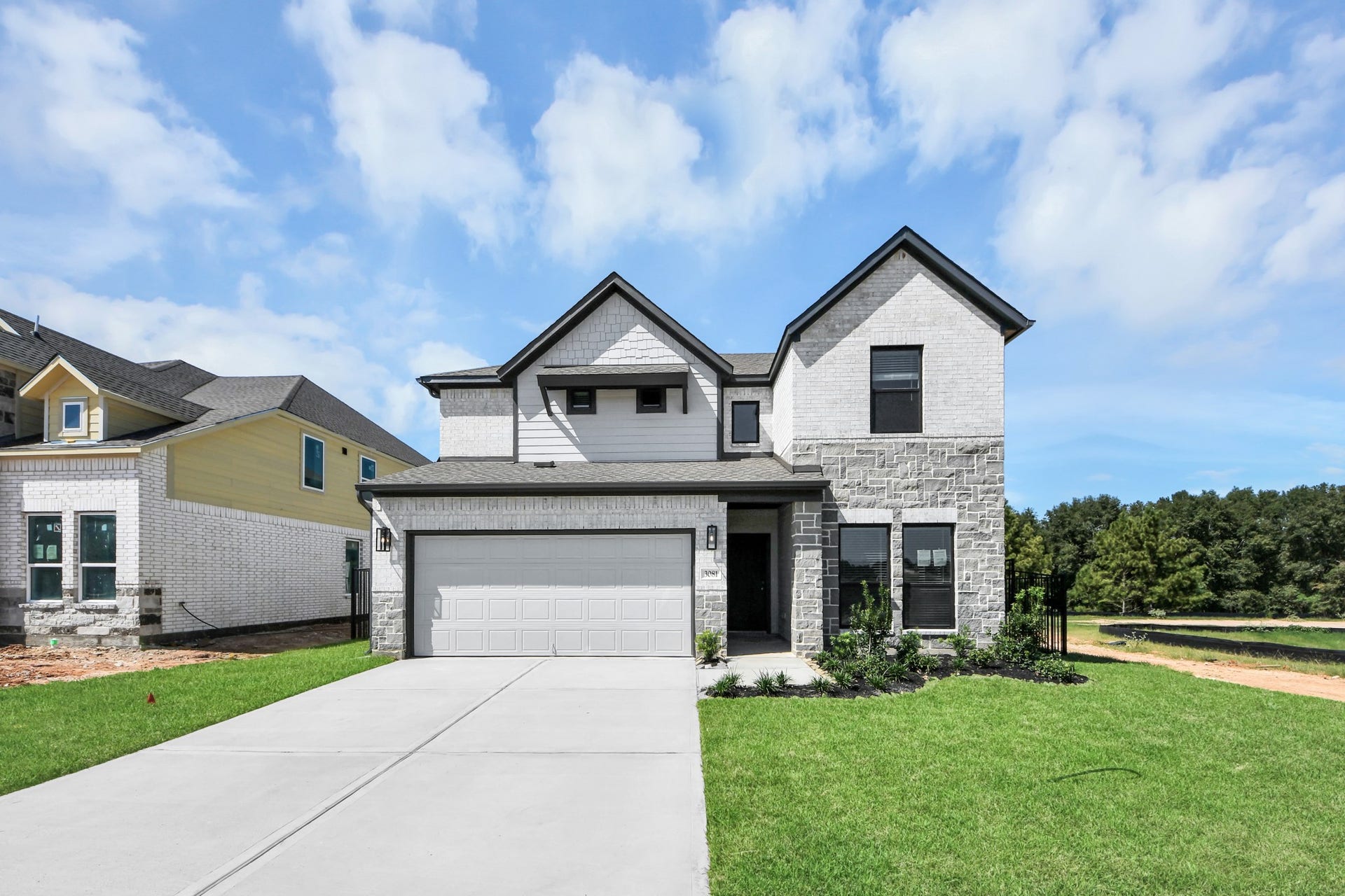 This home boasts lush green grass and meticulous landscaping. Its premium elevation showcases an exquisite blend of brick and stone features, complemented by modern coach lighting
