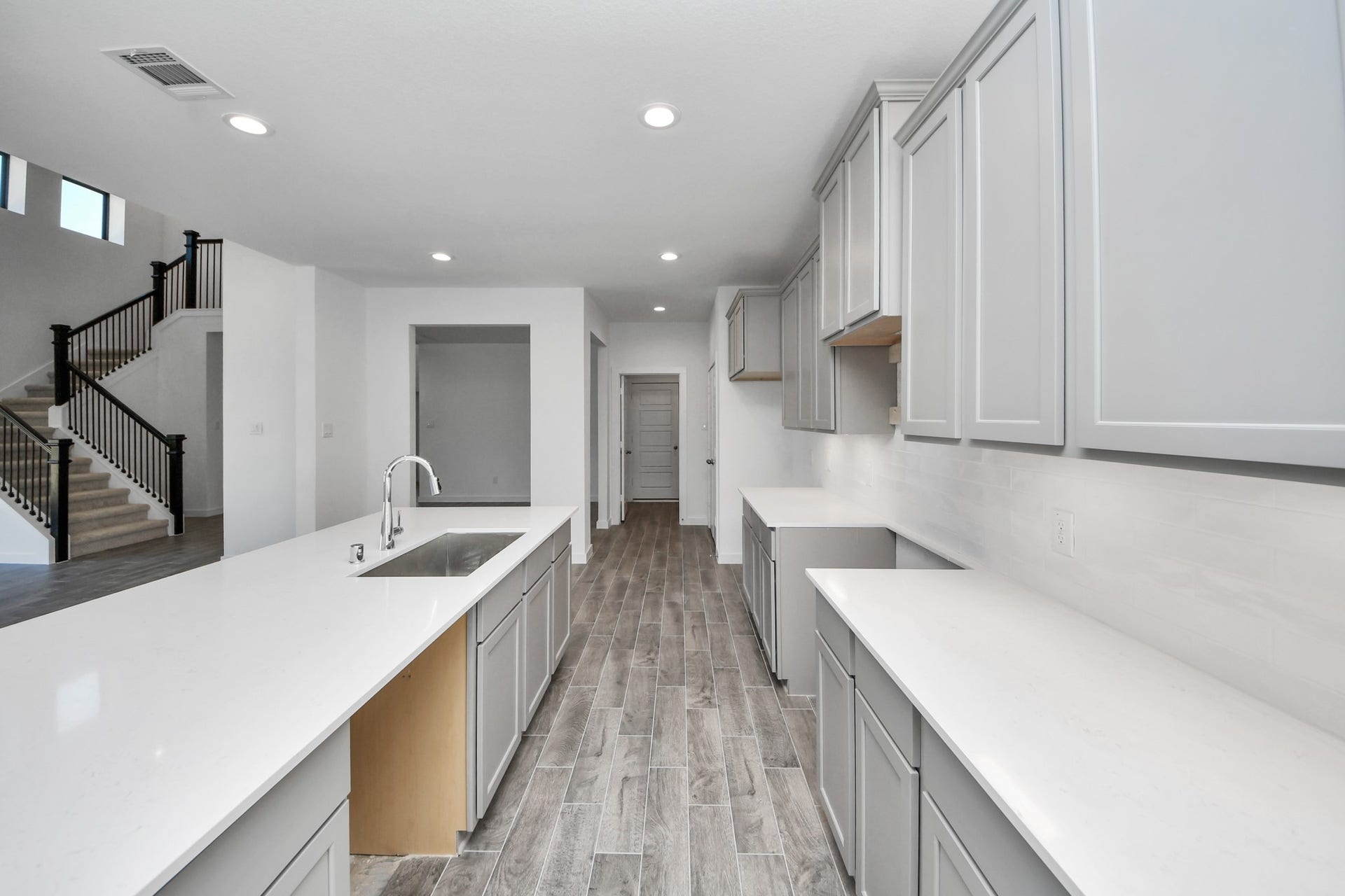 This kitchen is by far any chefs dream! This spacious kitchen features high ceilings, stained wood cabinets, granite countertop, SS appliances, modern tile backsplash, recessed lighting, extended counter space, granite kitchen island with double sink, and space for breakfast bar, and a walk-in pantry all overlooking your huge family room.