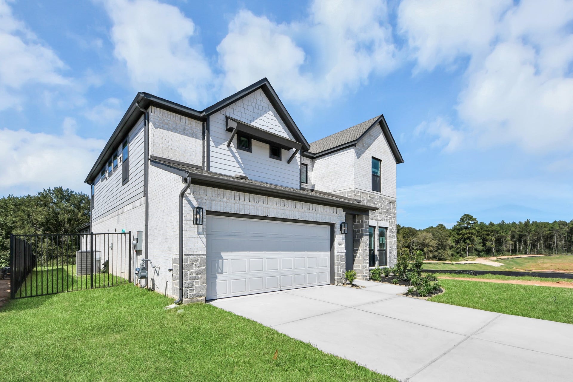Behold a lush landscape, impeccably maintained yard, and a premium elevation adorned with captivating brick and stone features.