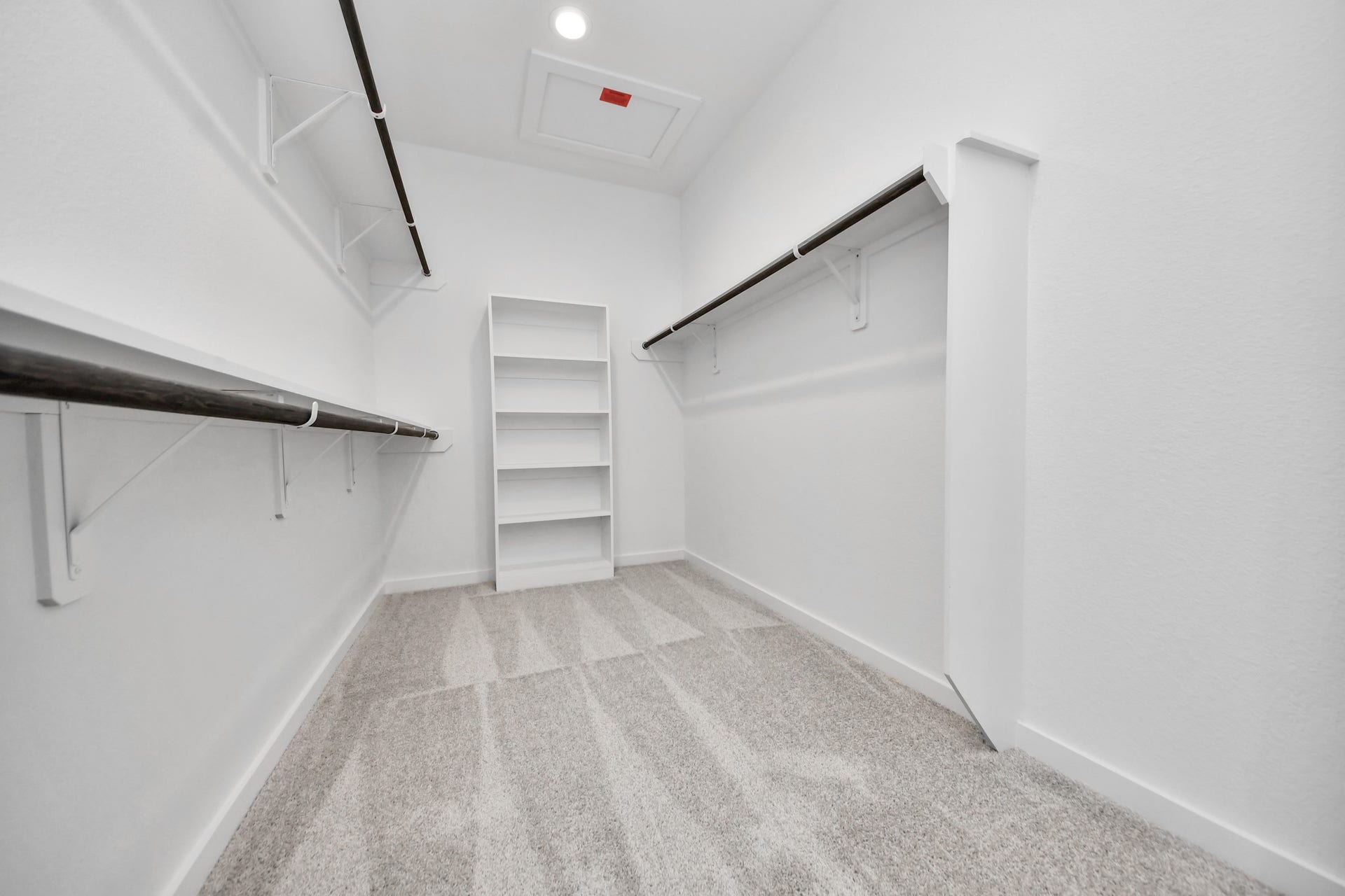 Walk-in closet that epitomizes luxury and practicality. This generously sized space features built-in shelving, offering abundant room for impeccable organization. High ceilings and recessed lighting create a bright and welcoming ambiance.