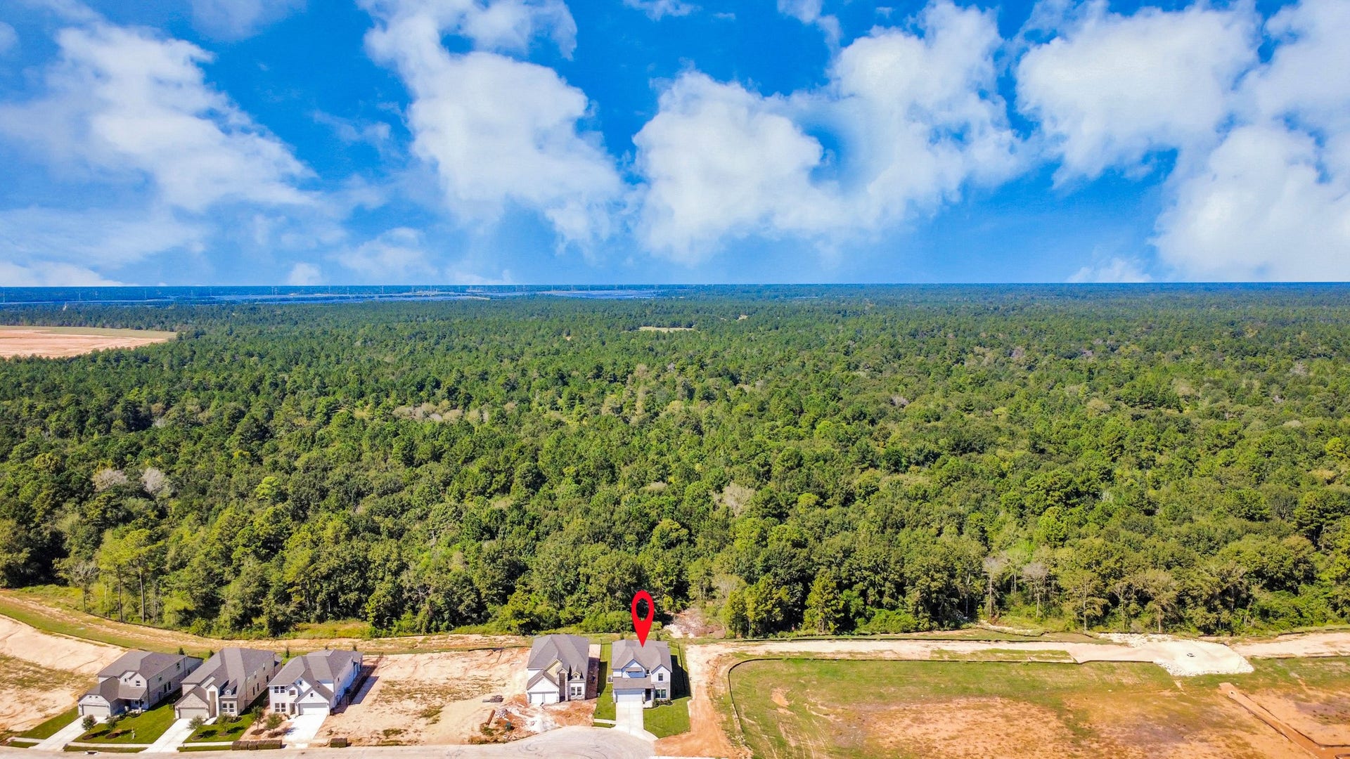 An aerial view of a spacious subdivision lot, highlighting a well-maintained yard and a fully fenced perimeter, offering both privacy and expansive outdoor space.