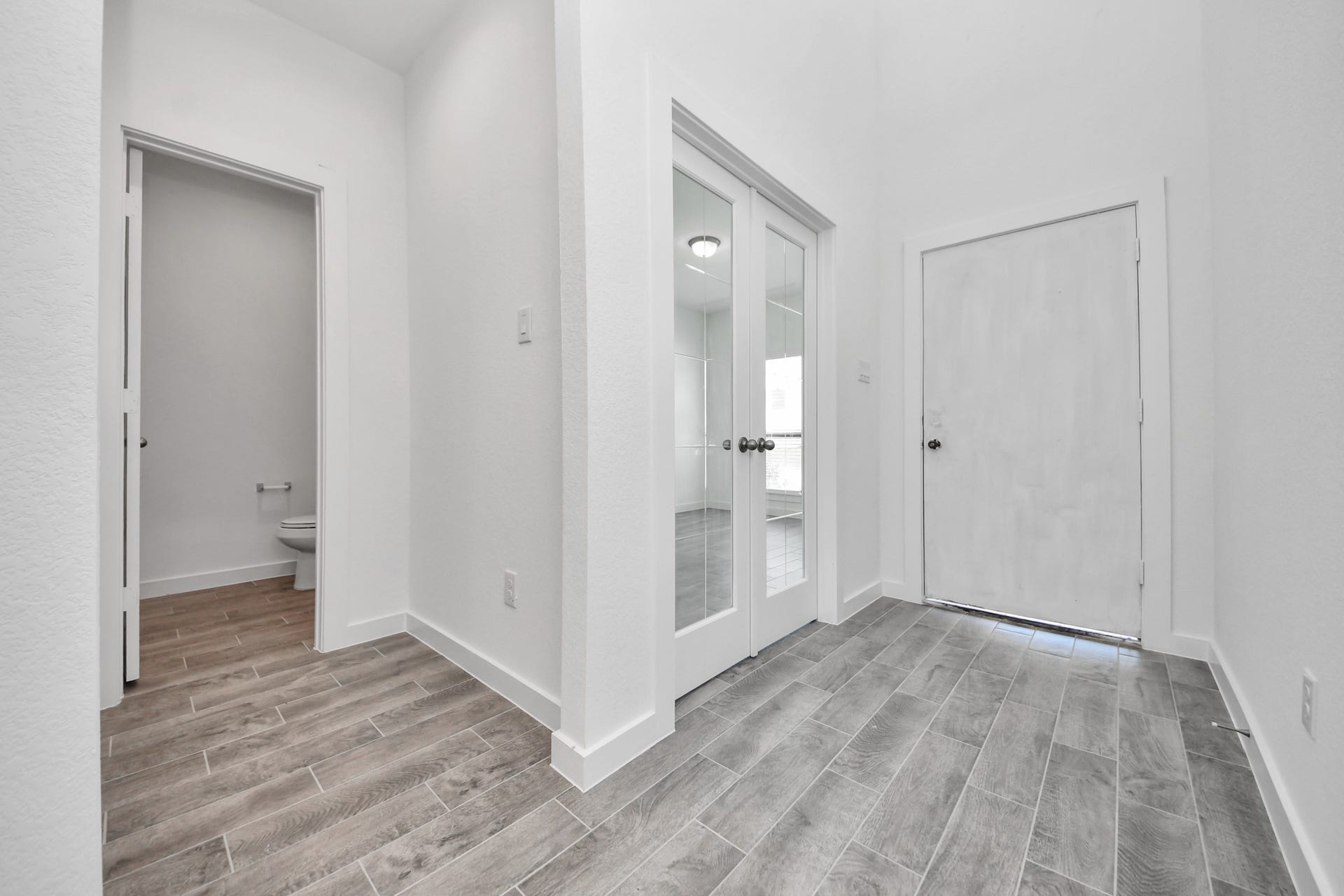 As you step into the threshold of this luxurious home, you'll soon be welcomed by an elegant glass door (to be installed). Inside, soaring ceilings amplify the spaciousness, while the refined wood-look tile flooring and oversized baseboards exude sophistication and charm.