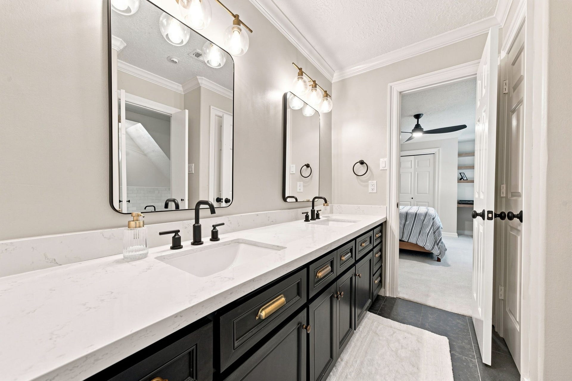 23 S Brokenfern Drive Drive, The Woodlands, TX 77380 Stunning Jack and Jill bathroom featuring double vanities, dual sinks, and elegant brass hardware finishes