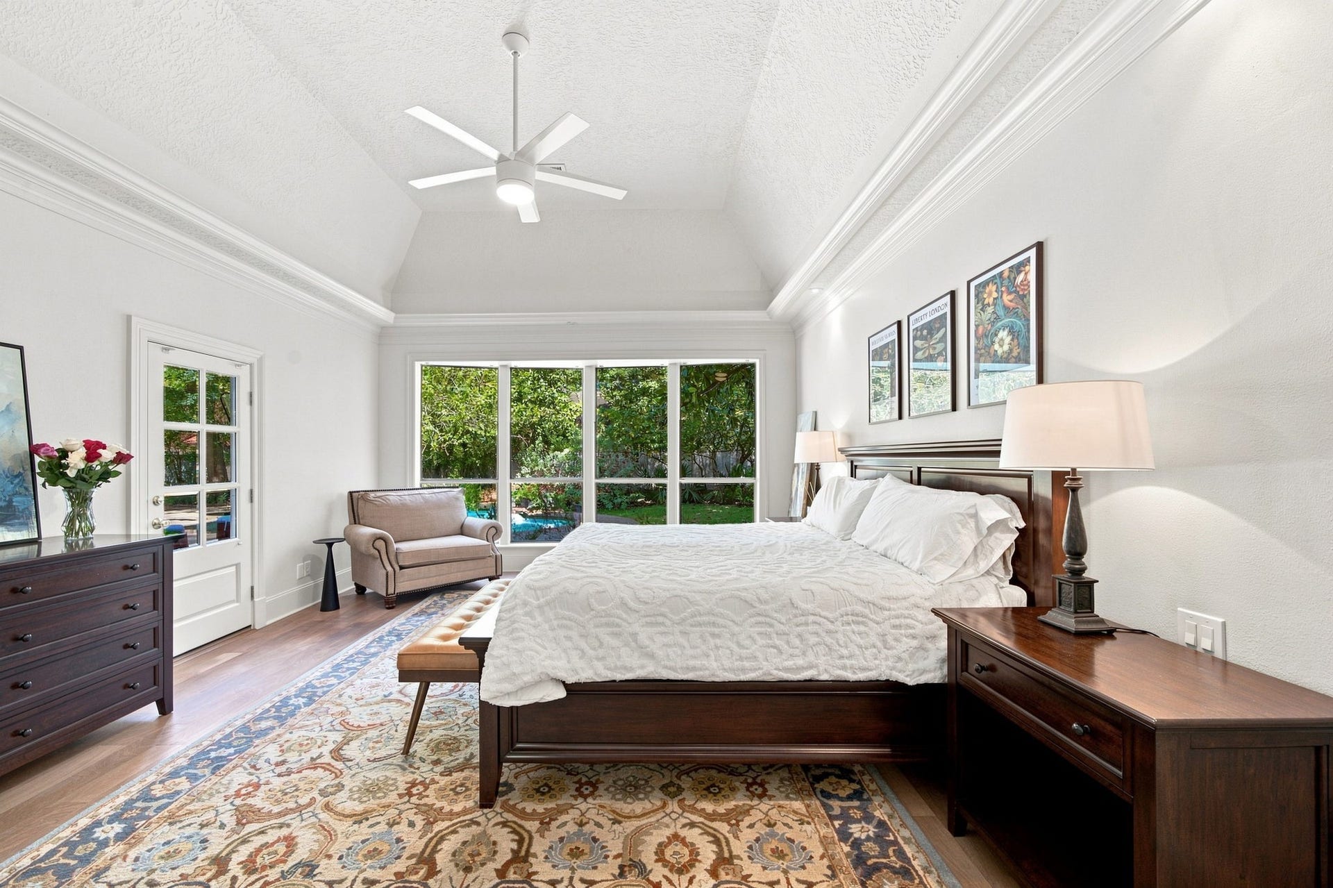 23 S Brokenfern Drive Drive, The Woodlands, TX 77380 Primary bedroom featuring vaulted ceilings, beautiful hardwood flooring, and direct access to the outdoor area with scenic views