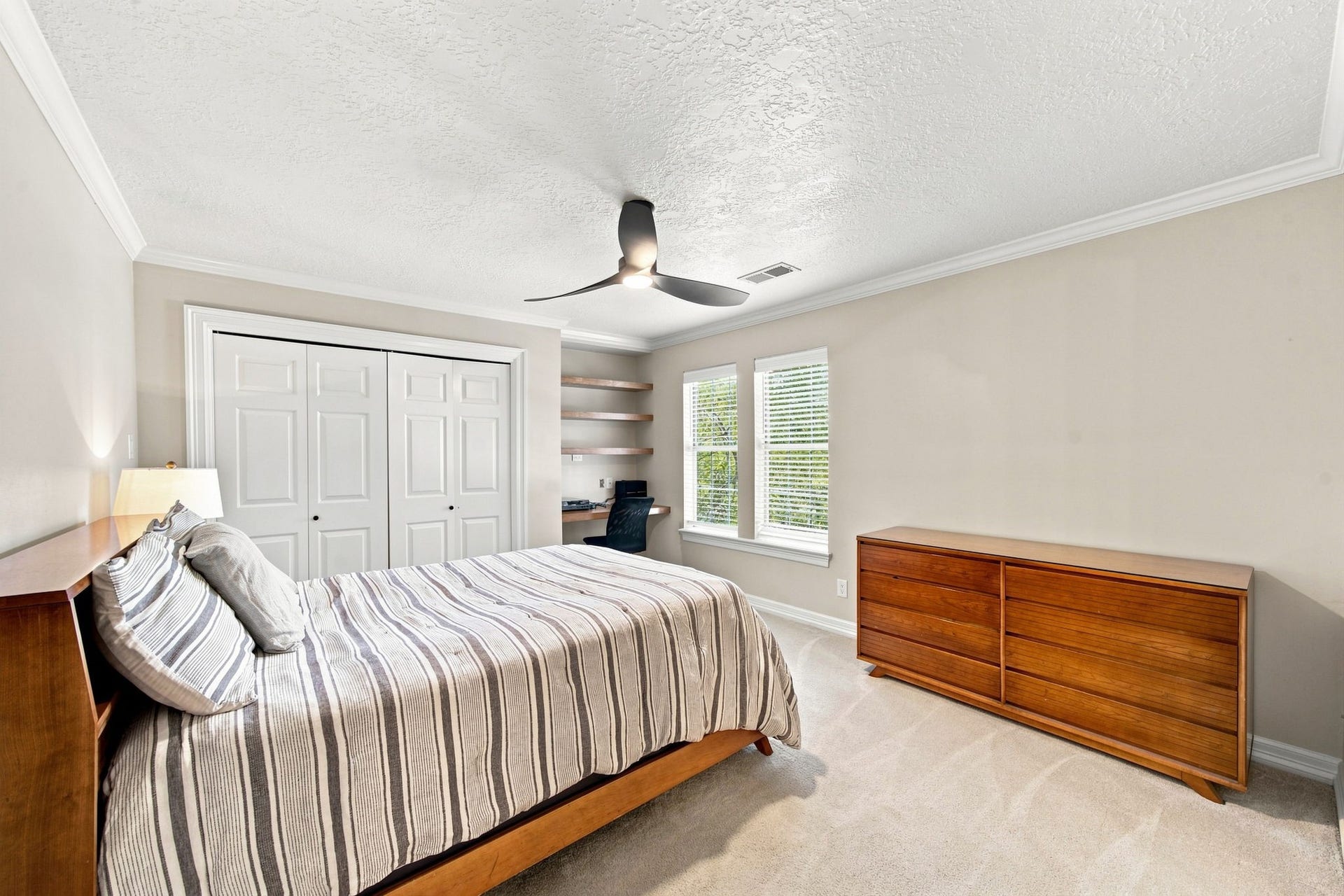 23 S Brokenfern Drive Drive, The Woodlands, TX 77380 Spacious upstairs bedroom featuring ample closet storage and a convenient built-in desk