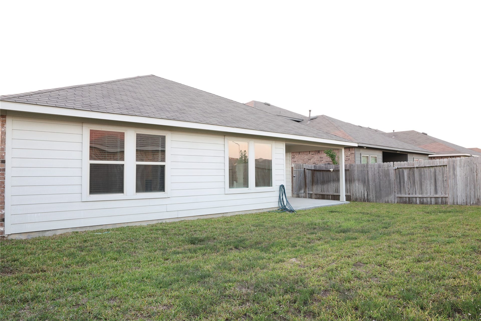 Spacious backyard featuring a well-maintained lawn, a cozy patio area, and privacy fencing.