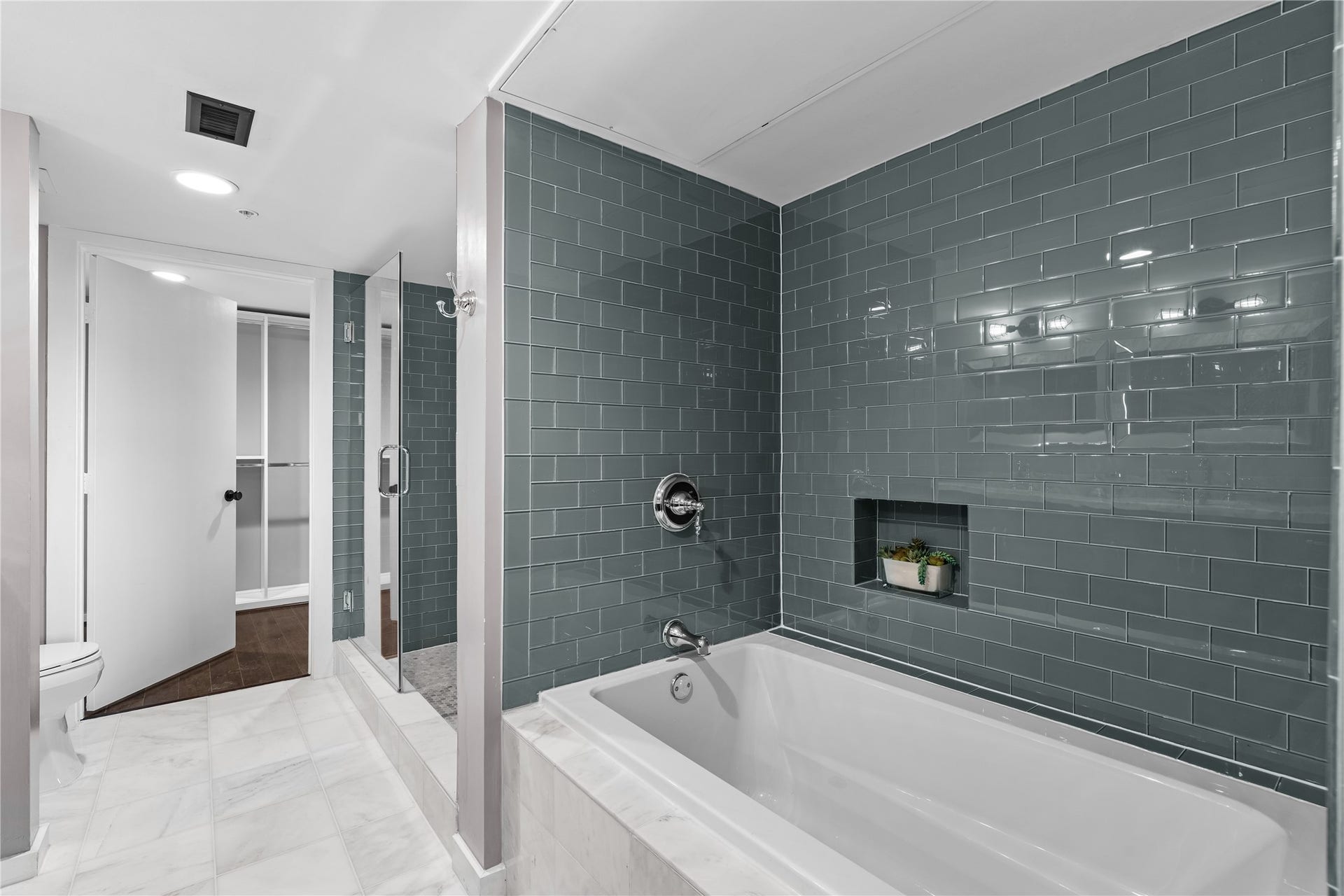 2000 Bagby St Street, #13430, Houston, TX 77002 A closer look at the remodeled primary bath highlights the separate soaking tub, oversized glass enclosed shower and striking tilework that adds depth and contrast to the space.