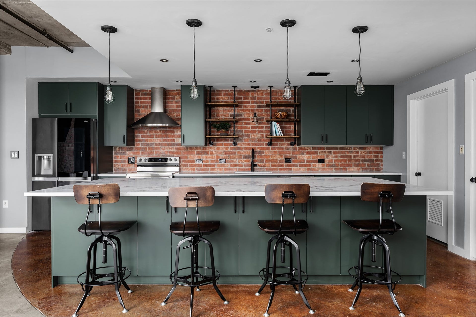 2000 Bagby St Street, #13430, Houston, TX 77002 A full view of the completely renovated kitchen highlights the expansive island, custom cabinetry and exposed brick, blending modern refinement with the lofts original industrial character.