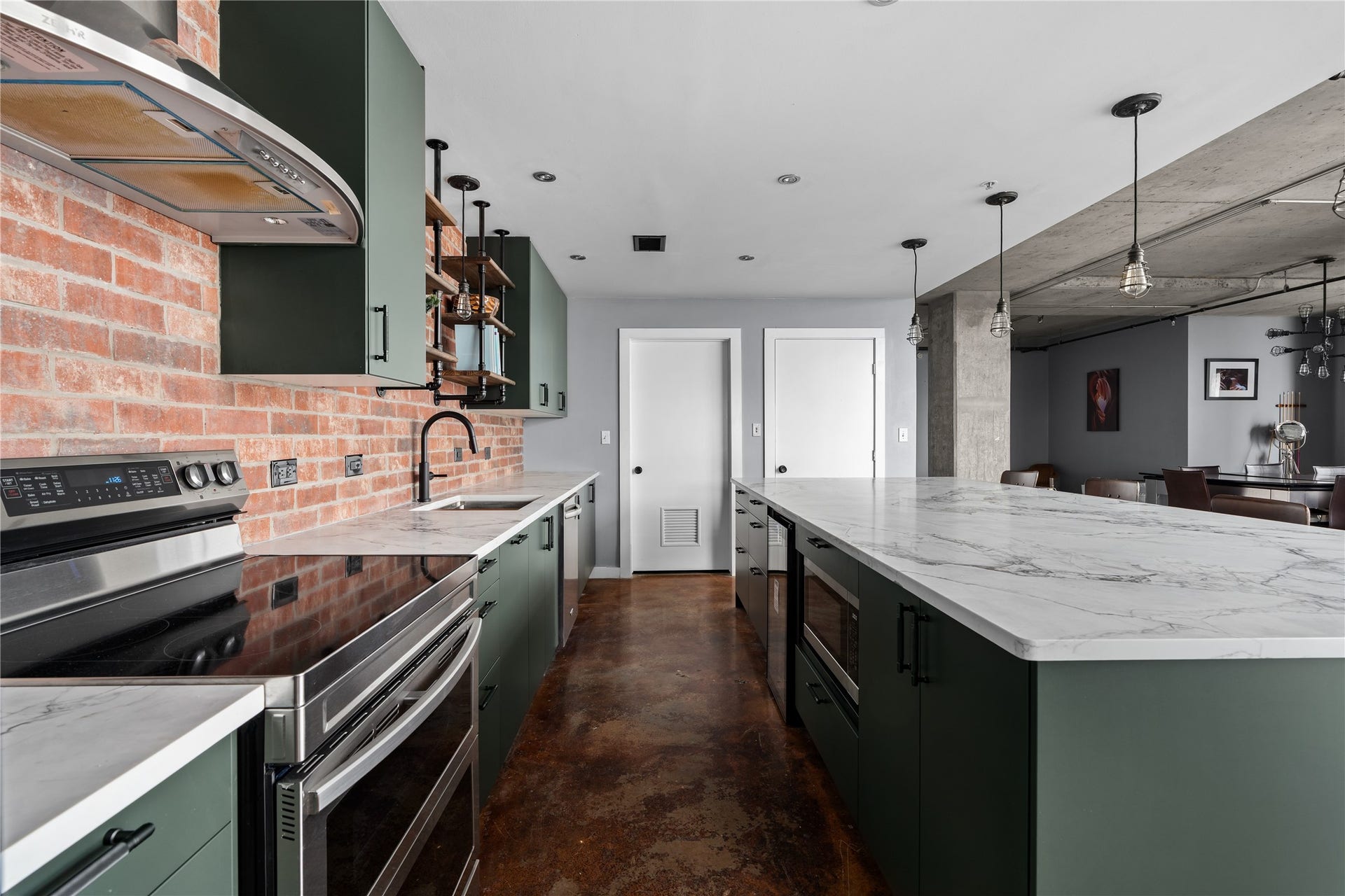 2000 Bagby St Street, #13430, Houston, TX 77002 A closer look at the renovated kitchen reveals generous prep space, extensive cabinetry and a long island designed for gathering, all set against the lofts original exposed brick.