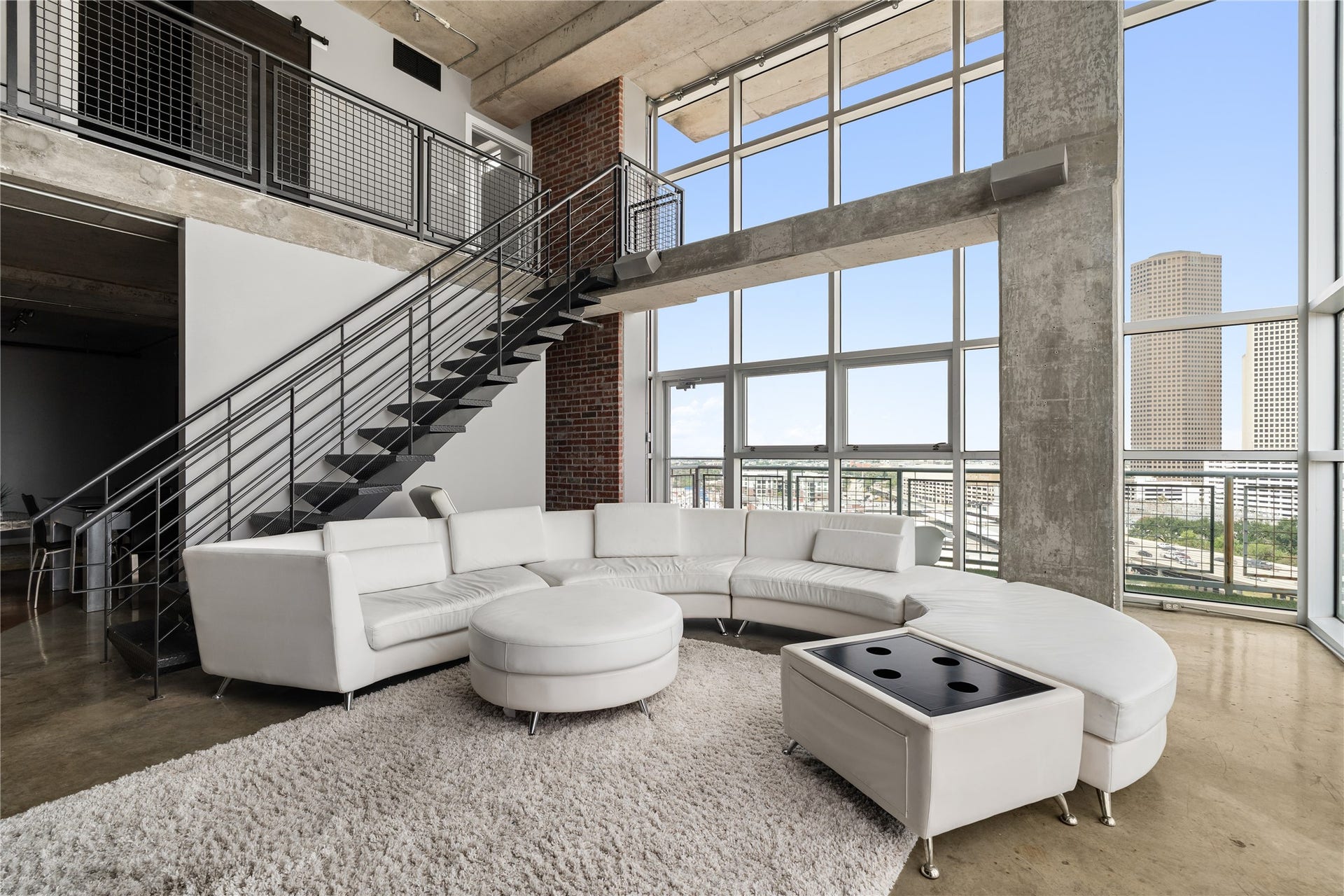 2000 Bagby St Street, #13430, Houston, TX 77002 A wider perspective captures the impressive volume of the two story living room, where soaring windows, exposed concrete and the open staircase create a true loft experience.