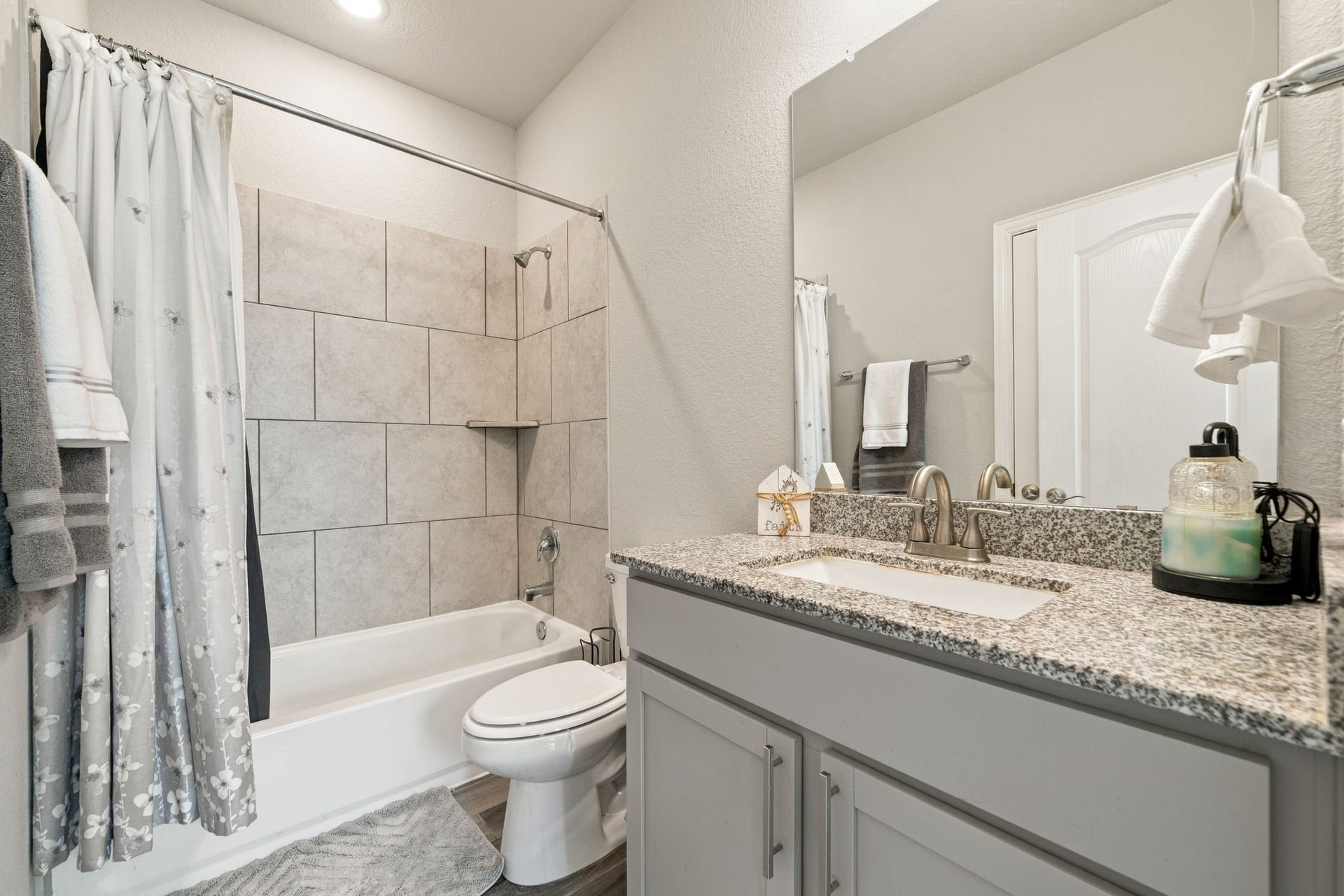 31410 Whitfield Court, Fulshear, TX 77441 Elegant Second bathroom featuring a sleek granite countertop with a modern sink, complemented by a tiled shower and tub combination.