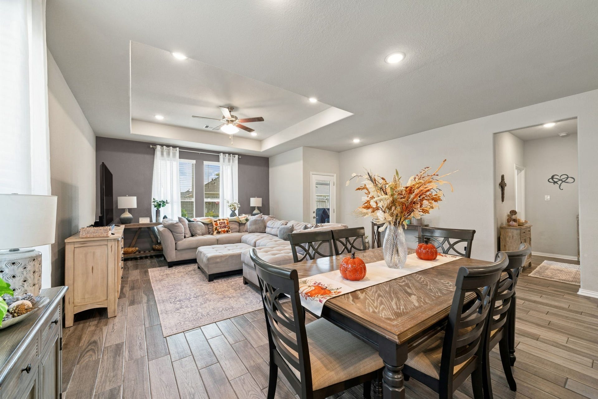 31410 Whitfield Court, Fulshear, TX 77441 Spacious open-concept living and dining area featuring elegant wood flooring, and stylish decor, perfect for both relaxation and entertaining.