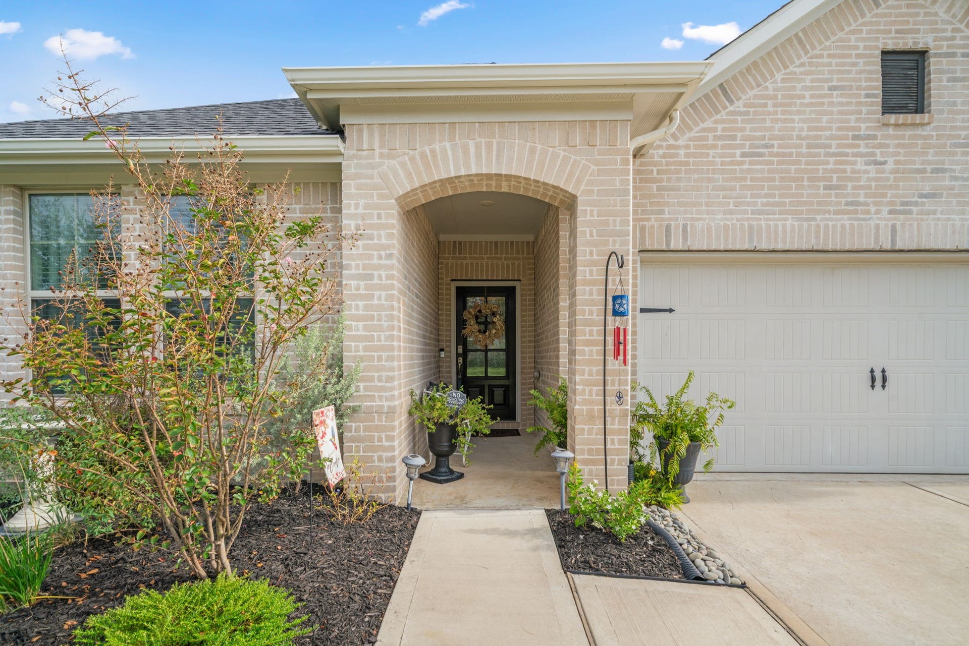 31410 Whitfield Court, Fulshear, TX 77441 Inviting covered entryway and well-maintained landscaping.