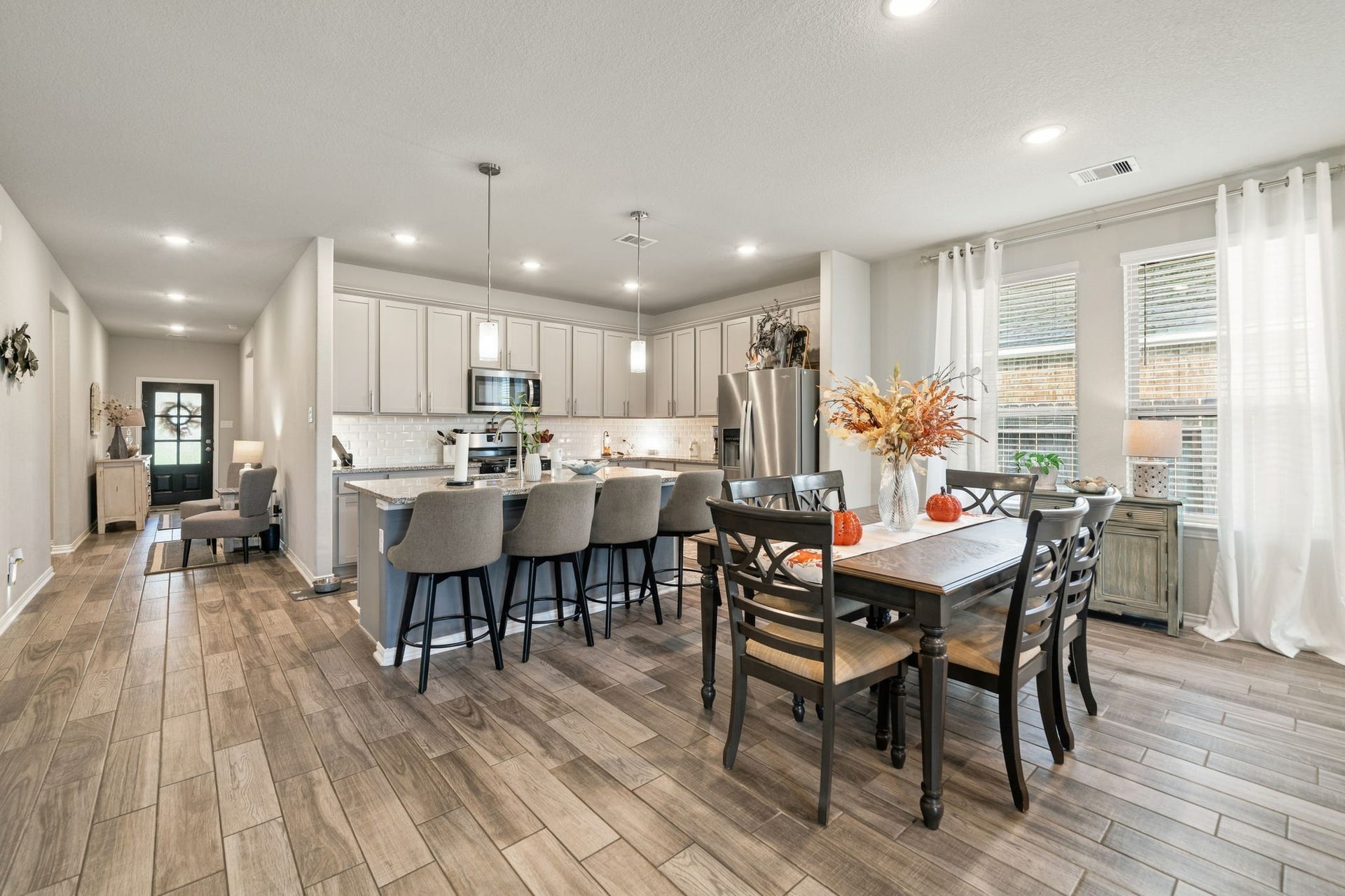31410 Whitfield Court, Fulshear, TX 77441 Spacious open-concept kitchen and dining area featuring modern appliances, a large island with seating, and abundant natural light from large windows, perfect for entertaining.