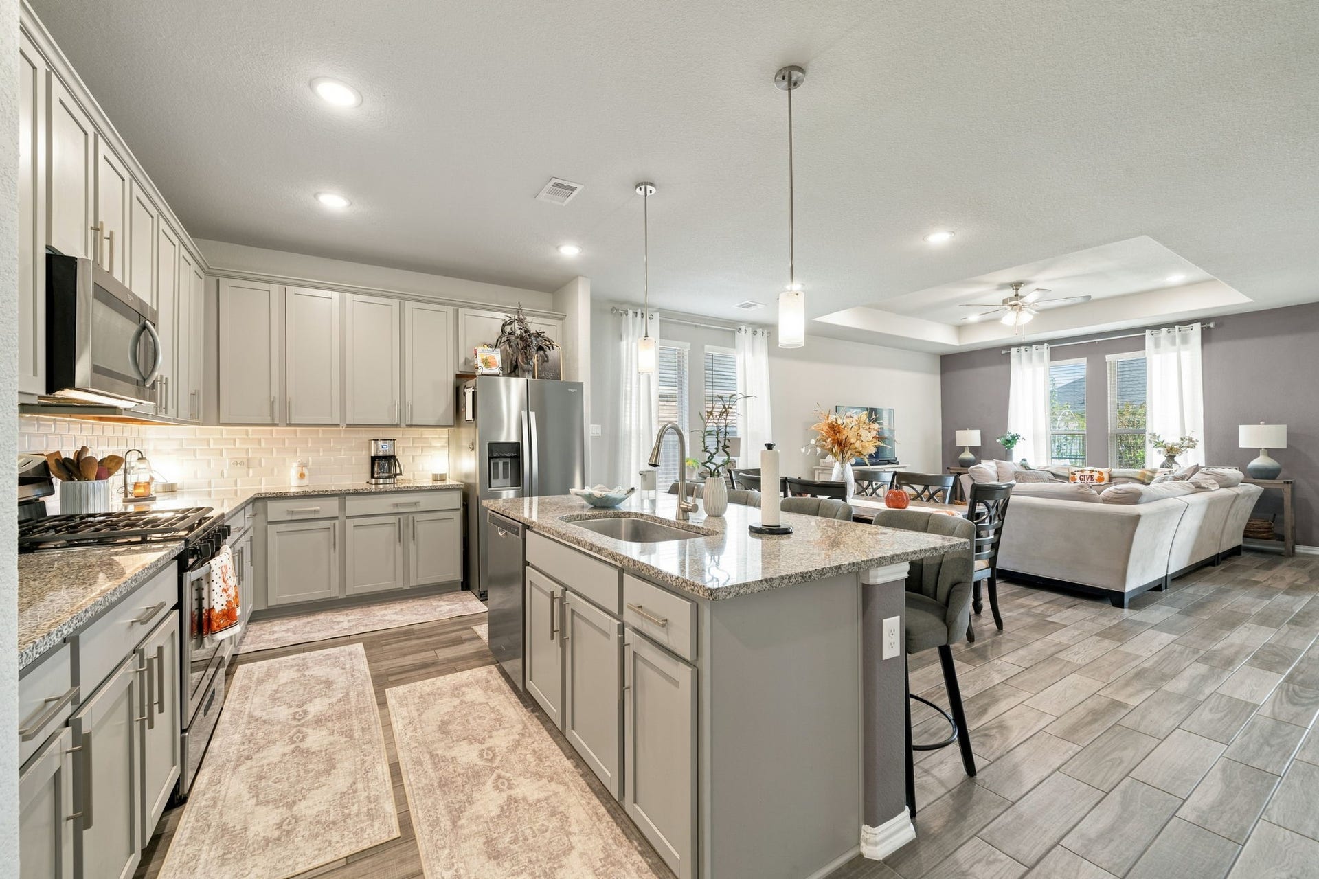 31410 Whitfield Court, Fulshear, TX 77441 Experience modern open-concept living with this beautifully designed kitchen and living area. The kitchen features sleek cabinetry, granite countertops, and stainless steel appliances, seamlessly flowing into a cozy living space with ample natural light and elegant finishes.