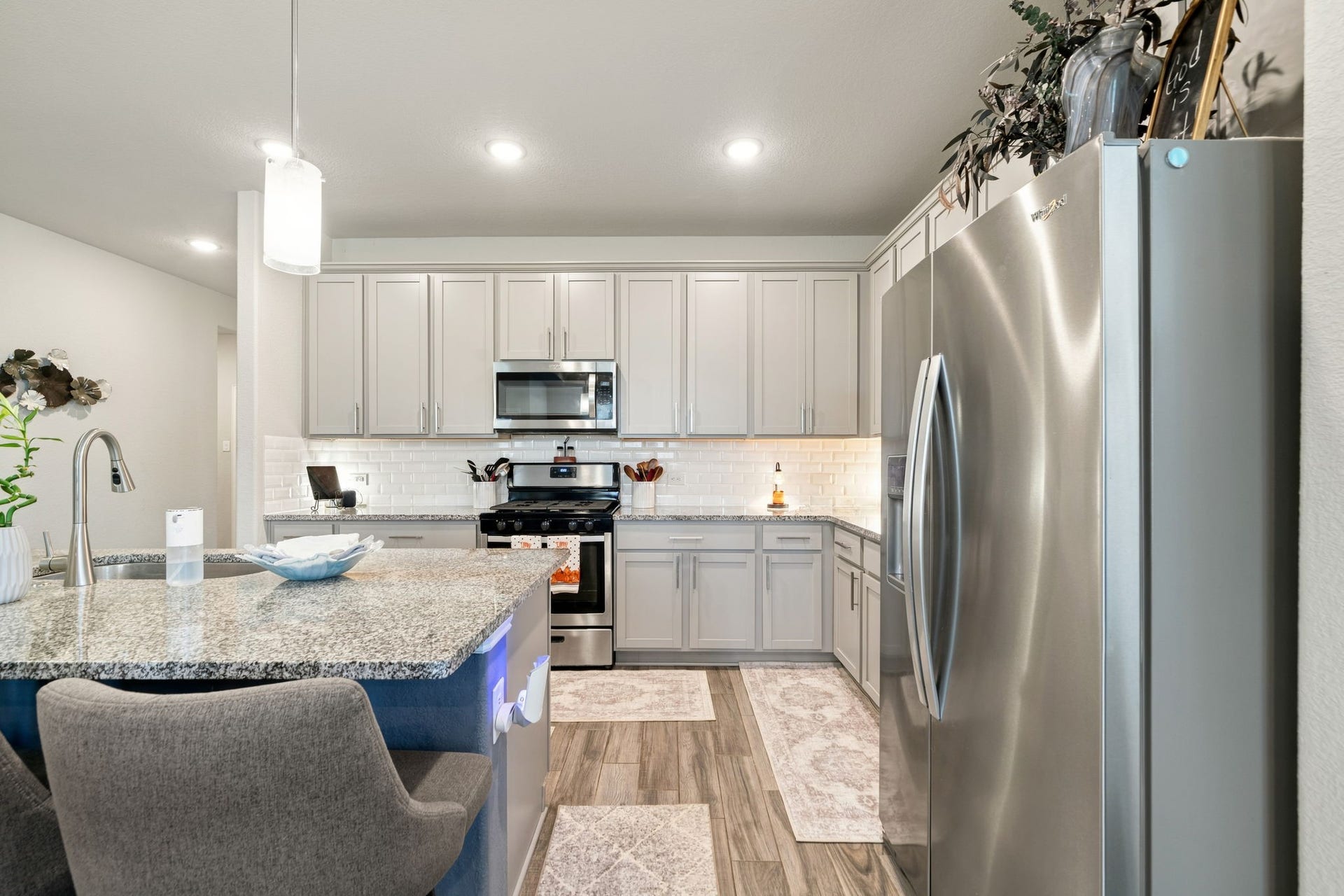 31410 Whitfield Court, Fulshear, TX 77441 Modern kitchen with sleek stainless steel appliances, granite countertops, and elegant cabinetry.