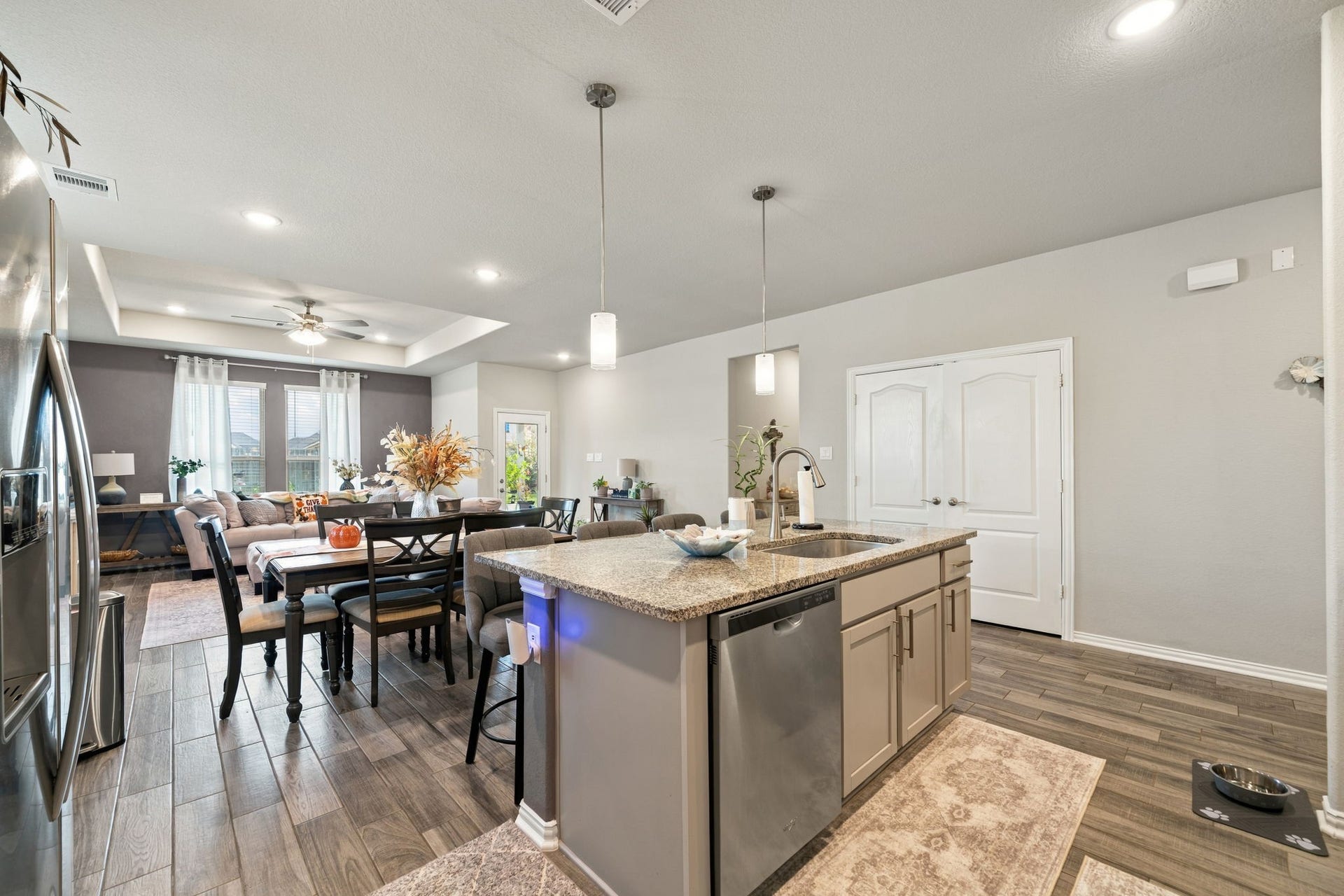31410 Whitfield Court, Fulshear, TX 77441 Spacious open-concept kitchen and living area featuring modern appliances, elegant lighting, and warm wood flooring, perfect for entertaining and family gatherings.