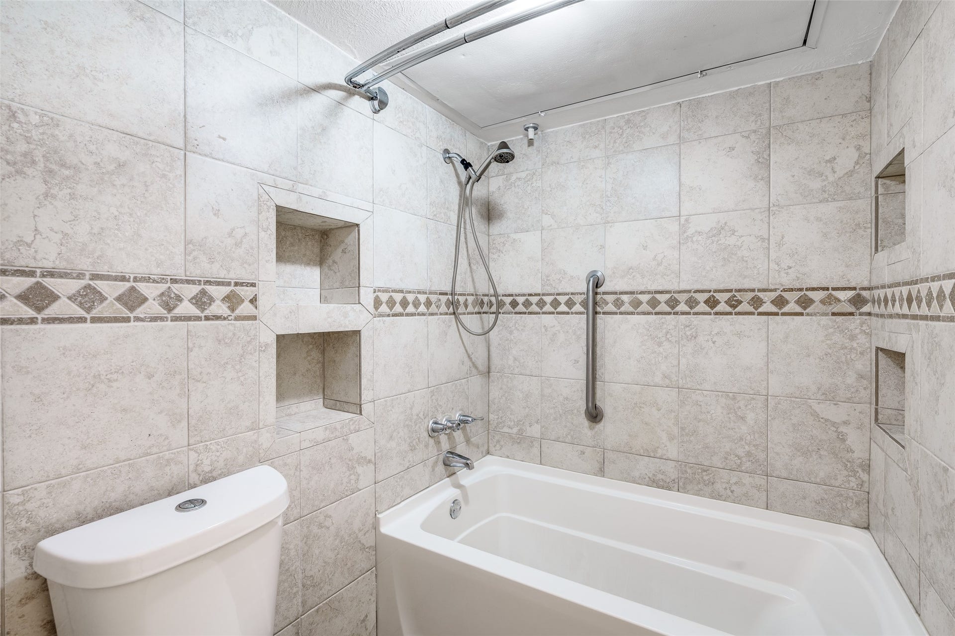 250 El Dorado Boulevard, #283, Houston, TX 77598 Step into the primary bathroom, offering a beautifully tiled shower/tub combo, tile flooring, and a convenient toilet, creating a blend of style and functionality.
