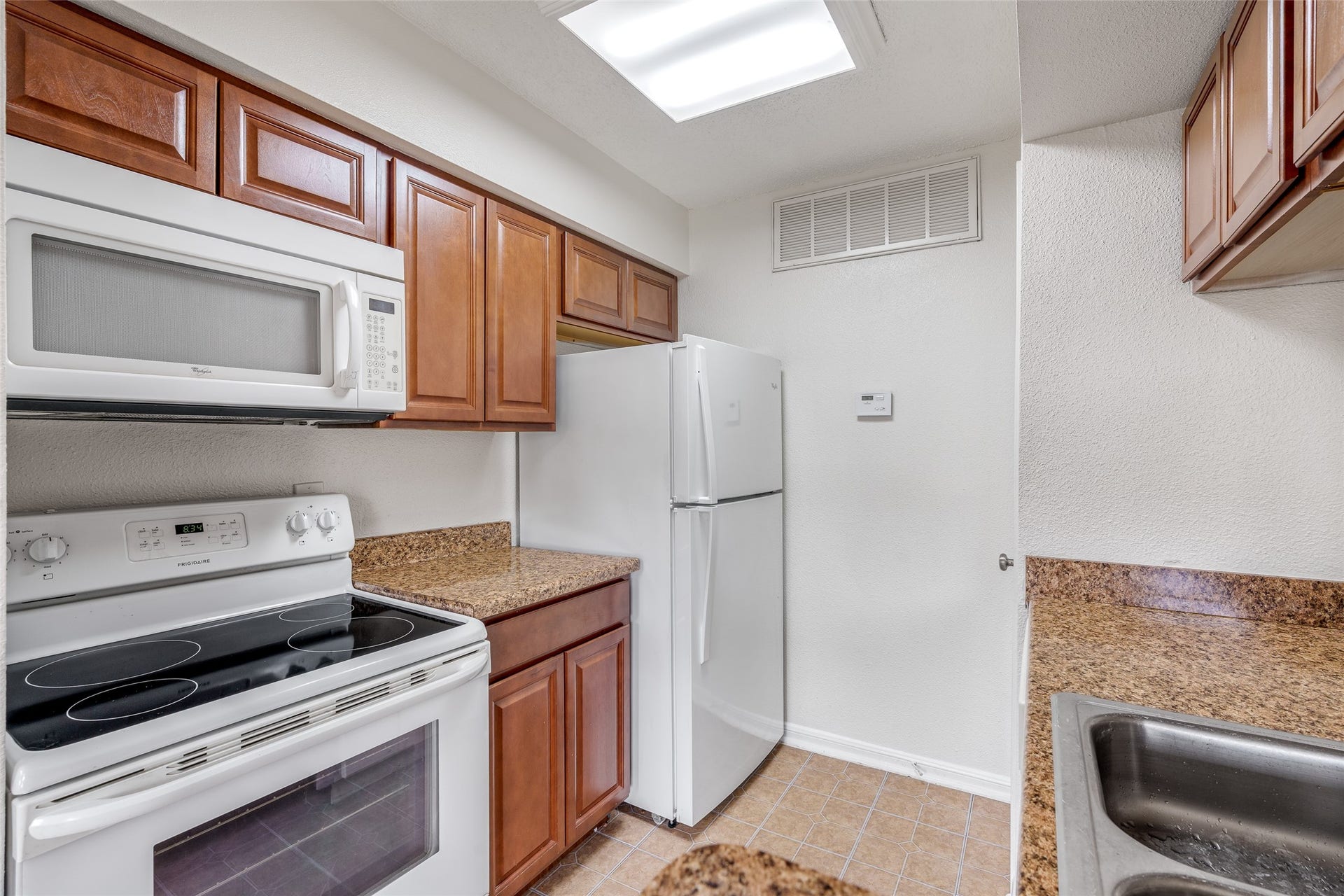 250 El Dorado Boulevard, #283, Houston, TX 77598 This charming kitchen features a convenient serving hatch perfect for entertaining, warm natural wood cabinets, and easy-to-maintain flooringblending function and style for everyday living.