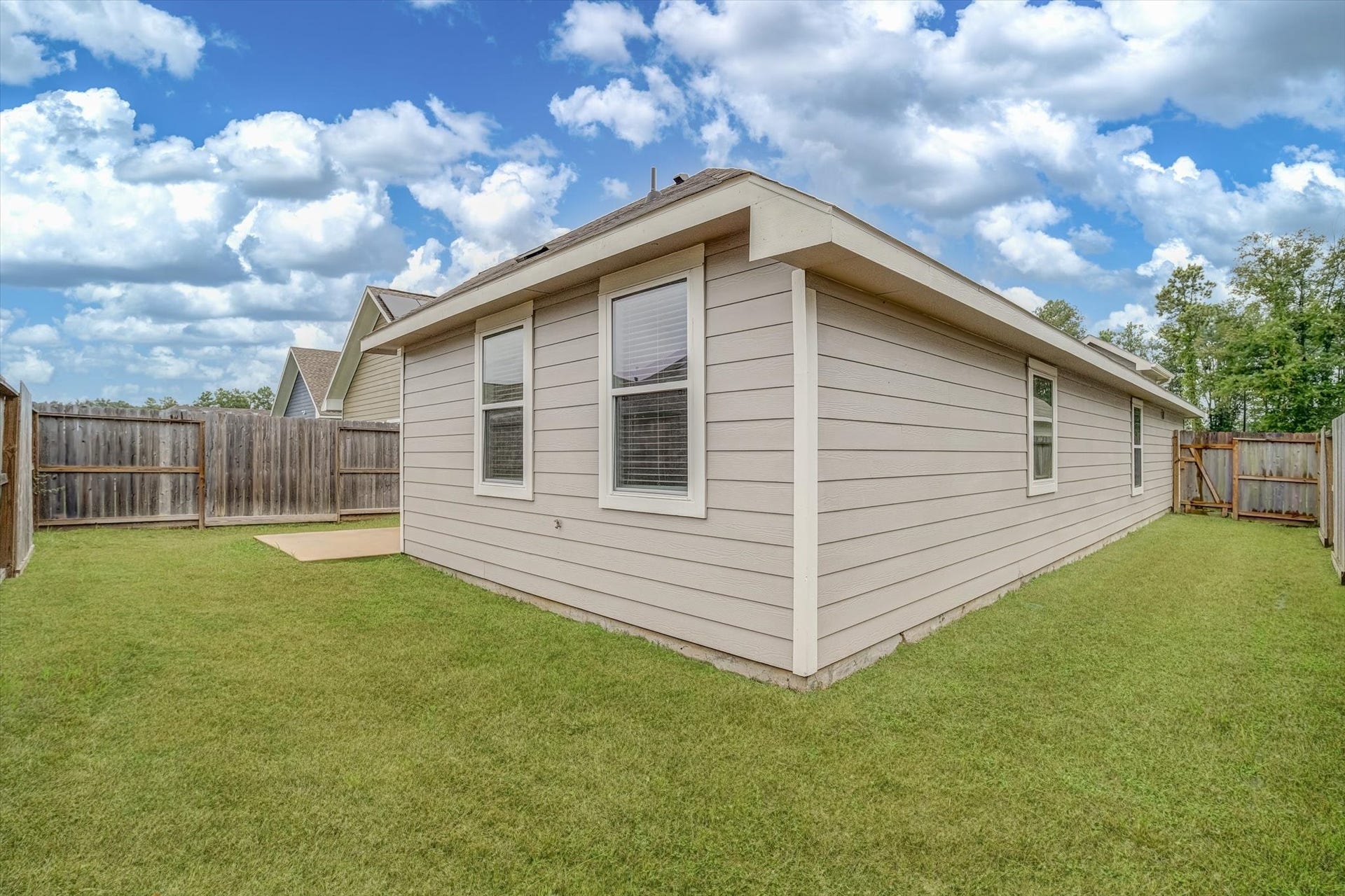 9607 Bright Song Lane, Houston, TX 77078 Charming backyard with lush green lawn and privacy fencing, perfect for relaxation and outdoor activities.