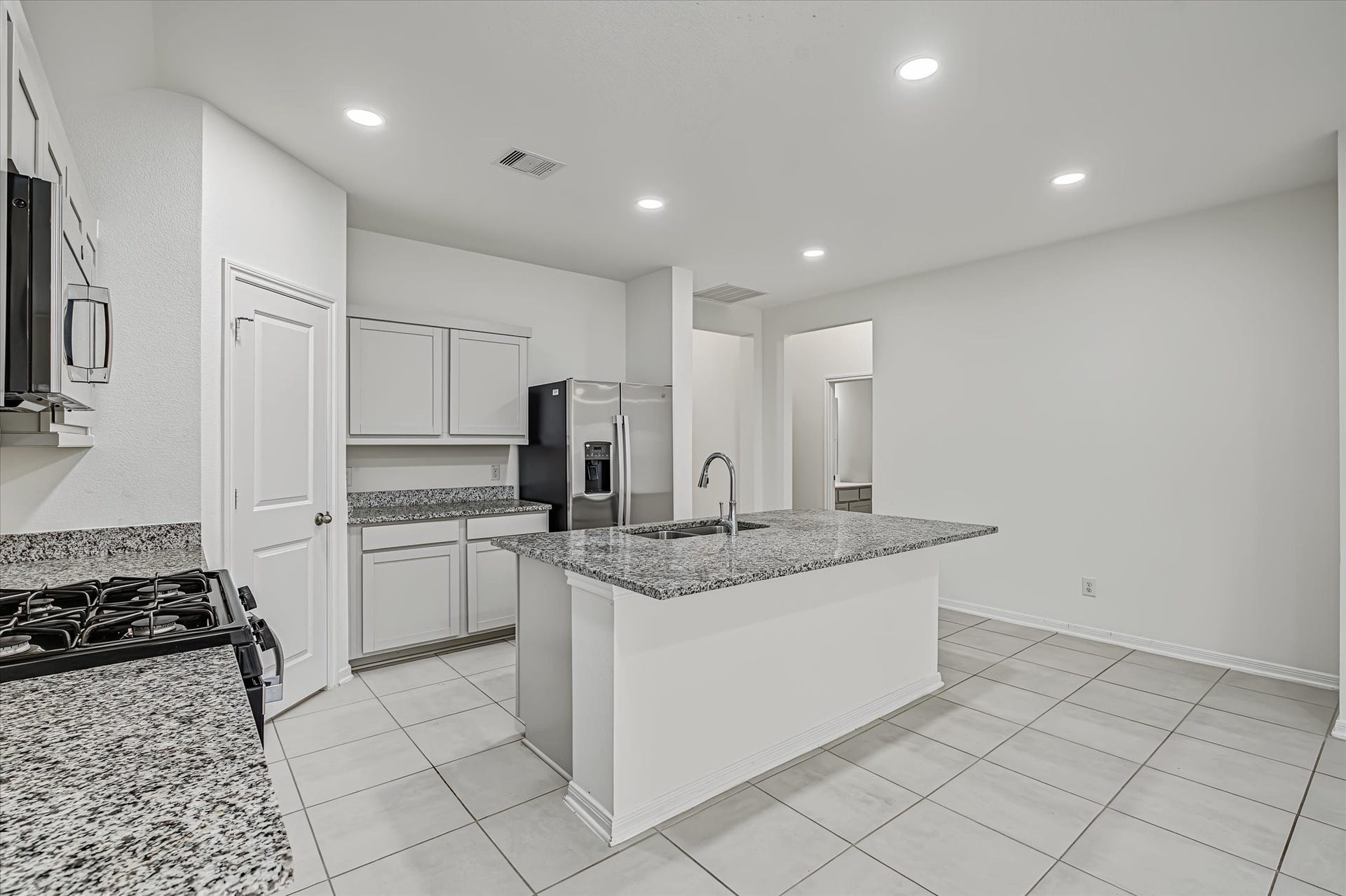 9607 Bright Song Lane, Houston, TX 77078 Spacious kitchen with sleek granite countertops, modern appliances, and ample cabinetry, perfect for culinary enthusiasts.