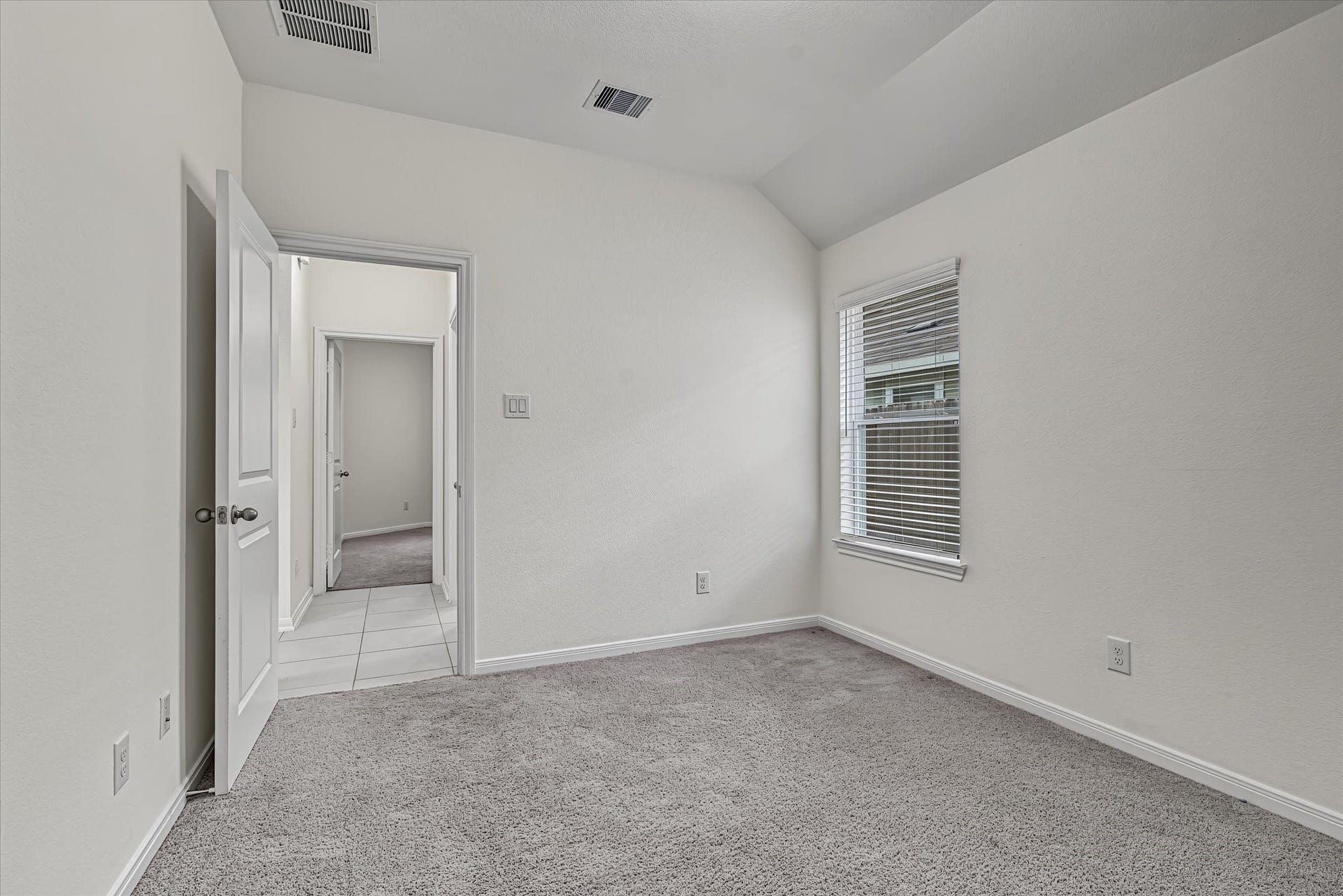 9607 Bright Song Lane, Houston, TX 77078 Cozy 3rd bedroom with plush carpeting, neutral walls, and a large window allowing natural light to stream in, creating a bright and inviting space.
