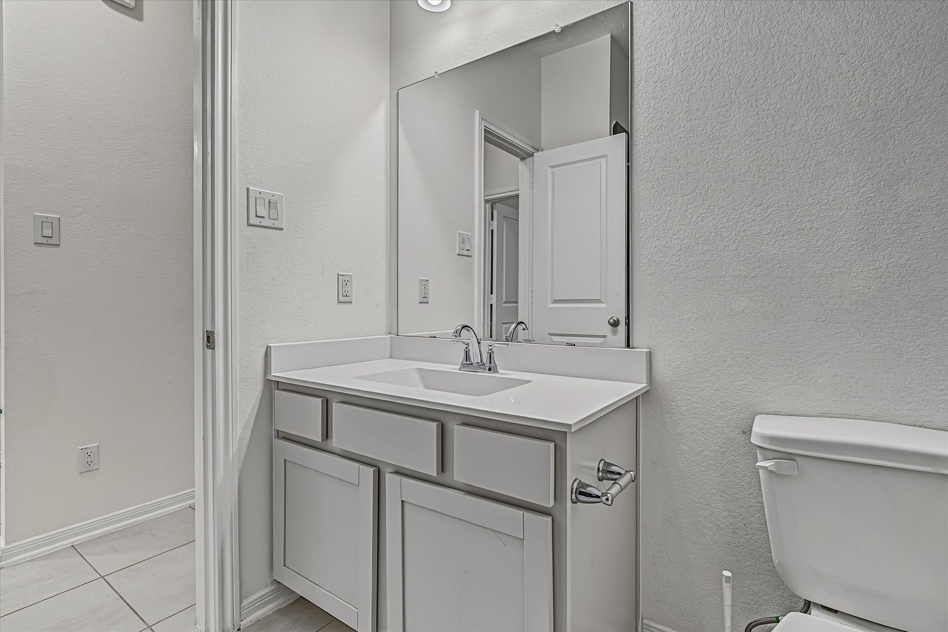 9607 Bright Song Lane, Houston, TX 77078 Modern 2nd bathroom featuring a sleek vanity with ample cabinet space, complemented by a large mirror and contemporary fixtures.