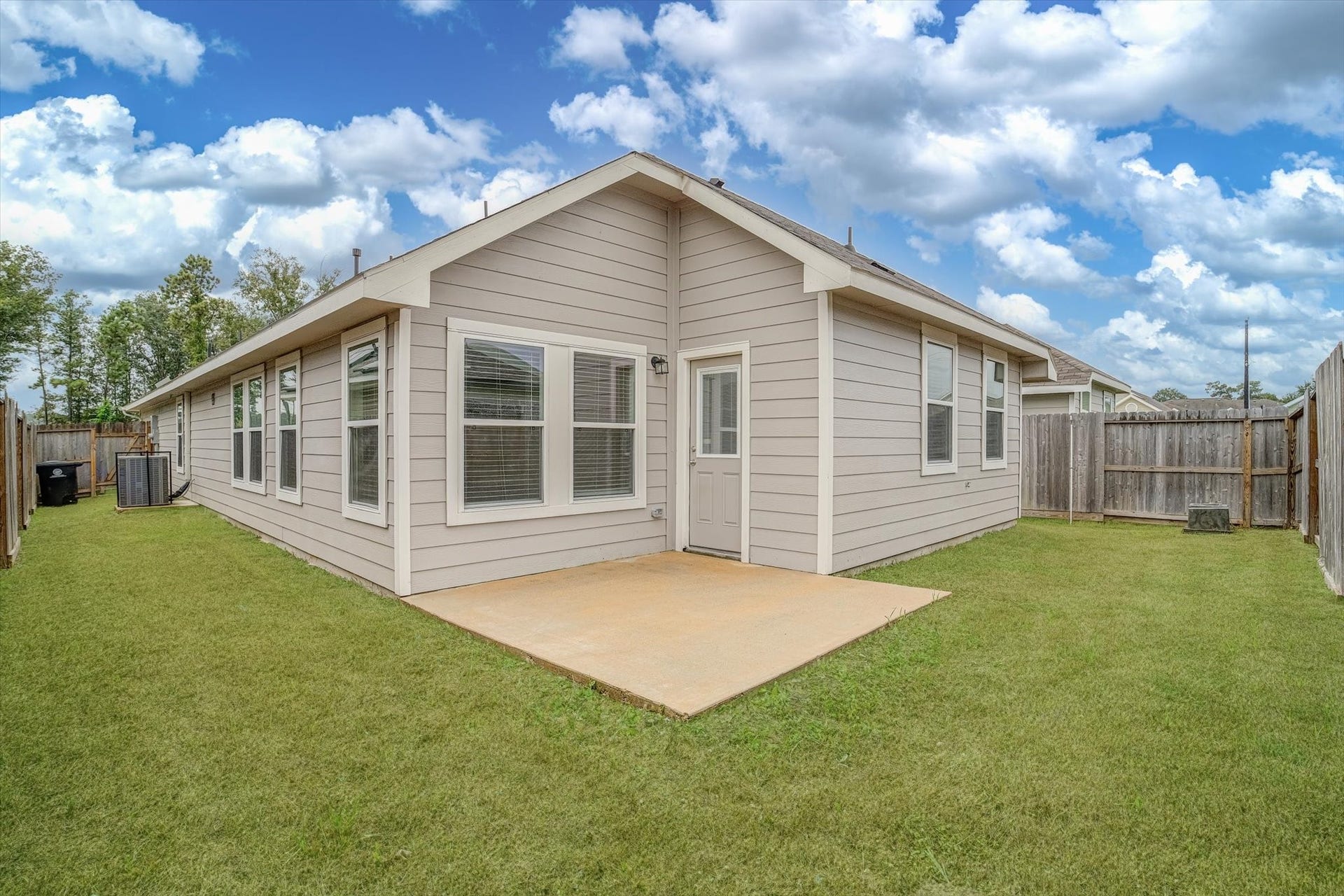9607 Bright Song Lane, Houston, TX 77078 Charming single-story home with a spacious backyard, featuring a well-maintained lawn and a concrete patio, ideal for outdoor relaxation and entertaining.