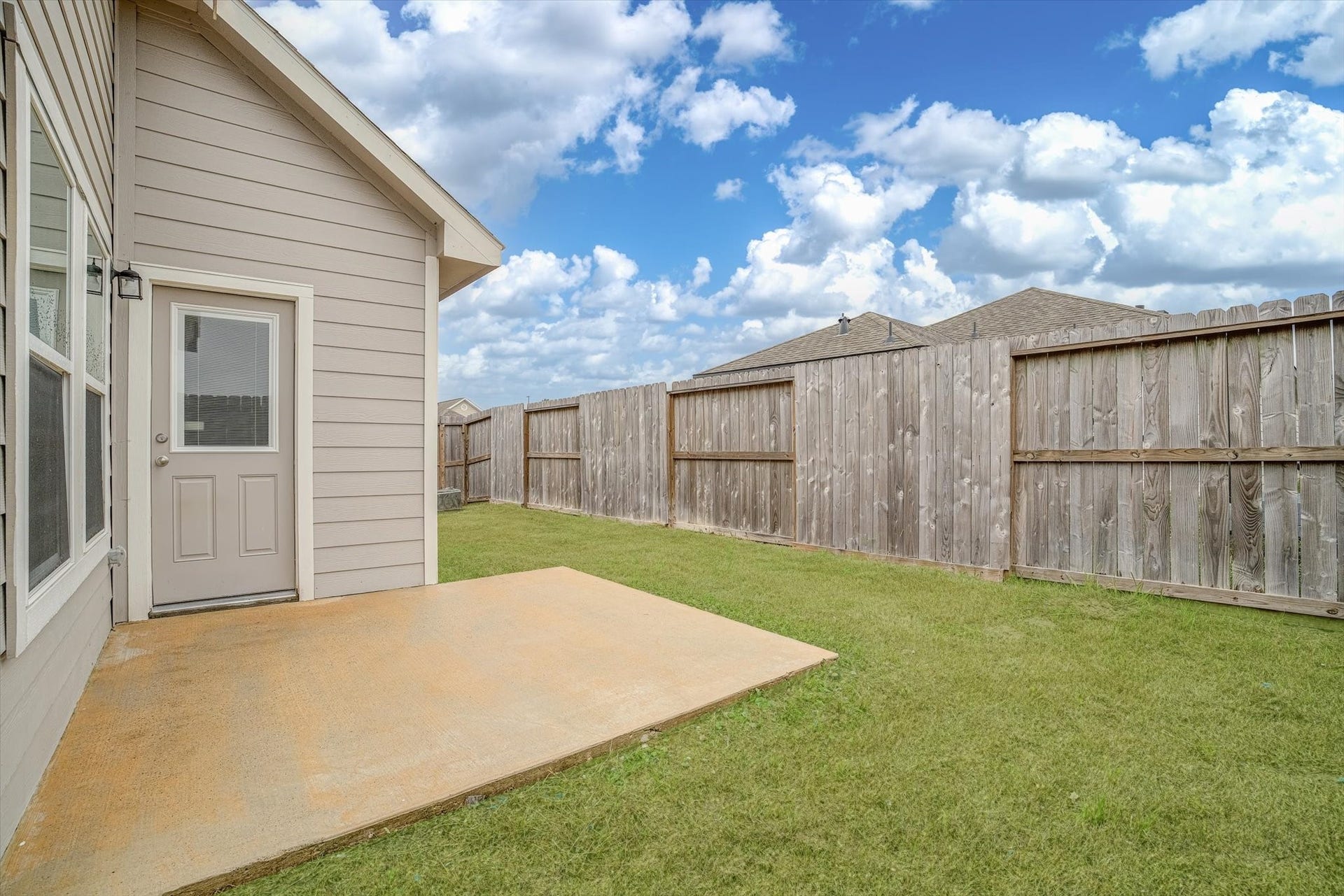 9607 Bright Song Lane, Houston, TX 77078 Charming backyard with a private fenced area and a cozy patio, perfect for outdoor relaxation.