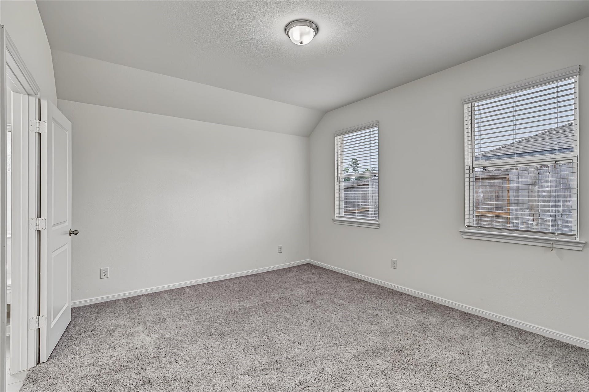 9607 Bright Song Lane, Houston, TX 77078 Bright and airy bedroom featuring plush carpeting, two large windows for natural light, and a neutral color palette, creating a welcoming and serene atmosphere.