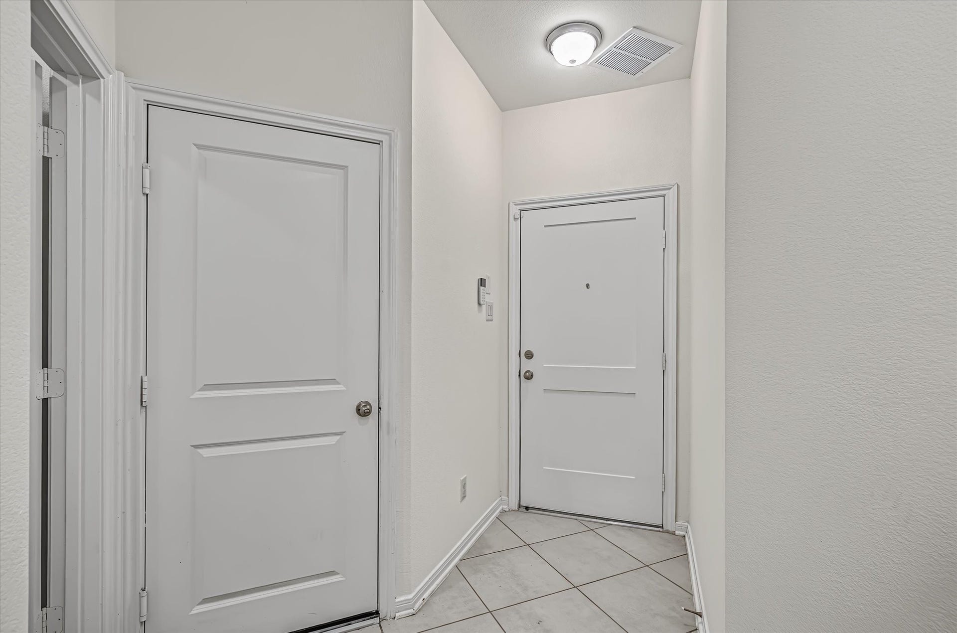 9607 Bright Song Lane, Houston, TX 77078 Inviting entryway with neutral tile flooring and clean, crisp white walls, creating a welcoming atmosphere.