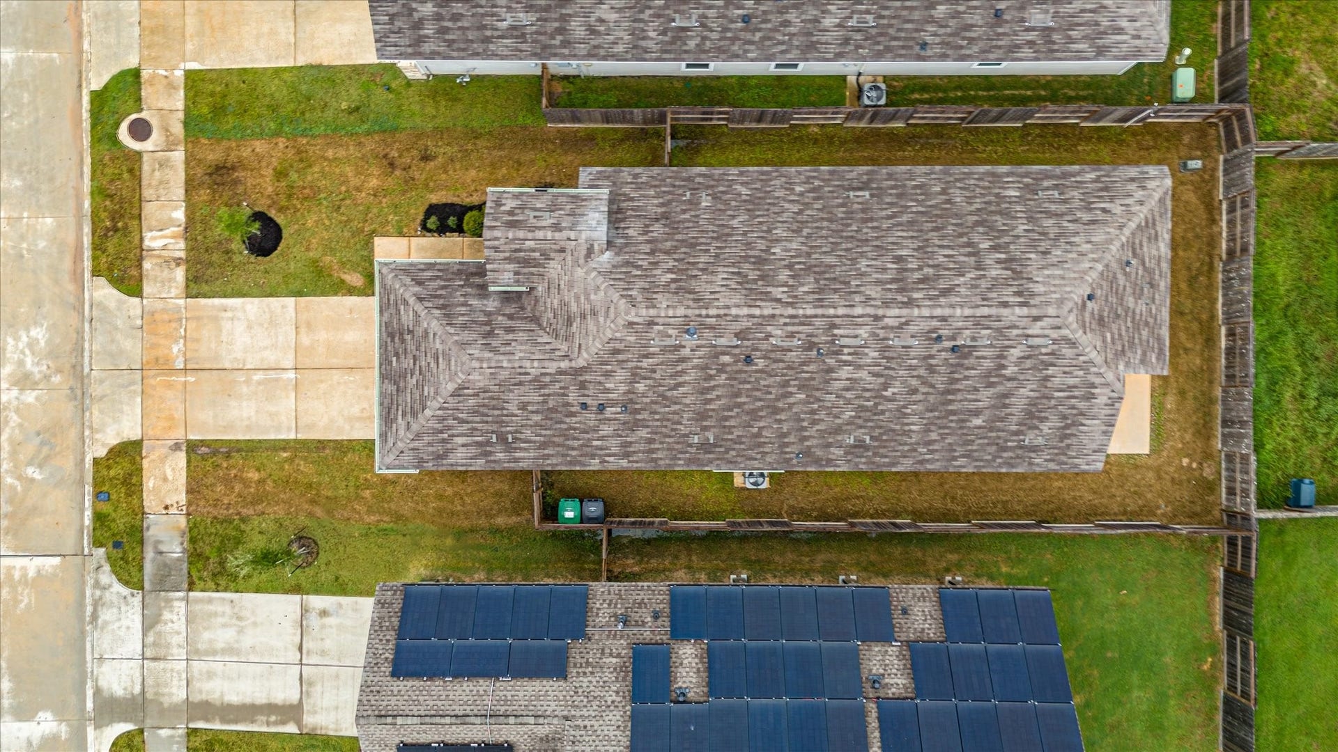 9607 Bright Song Lane, Houston, TX 77078 Aerial view of a well-maintained property featuring a spacious roof and neatly landscaped yard, with ample driveway space and a fenced backyard for privacy.