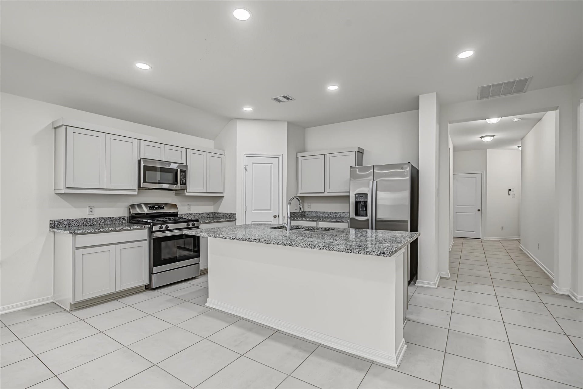 9607 Bright Song Lane, Houston, TX 77078 Spacious kitchen with modern stainless steel appliances, sleek granite countertops, and ample cabinetry, offering a bright and inviting cooking space.