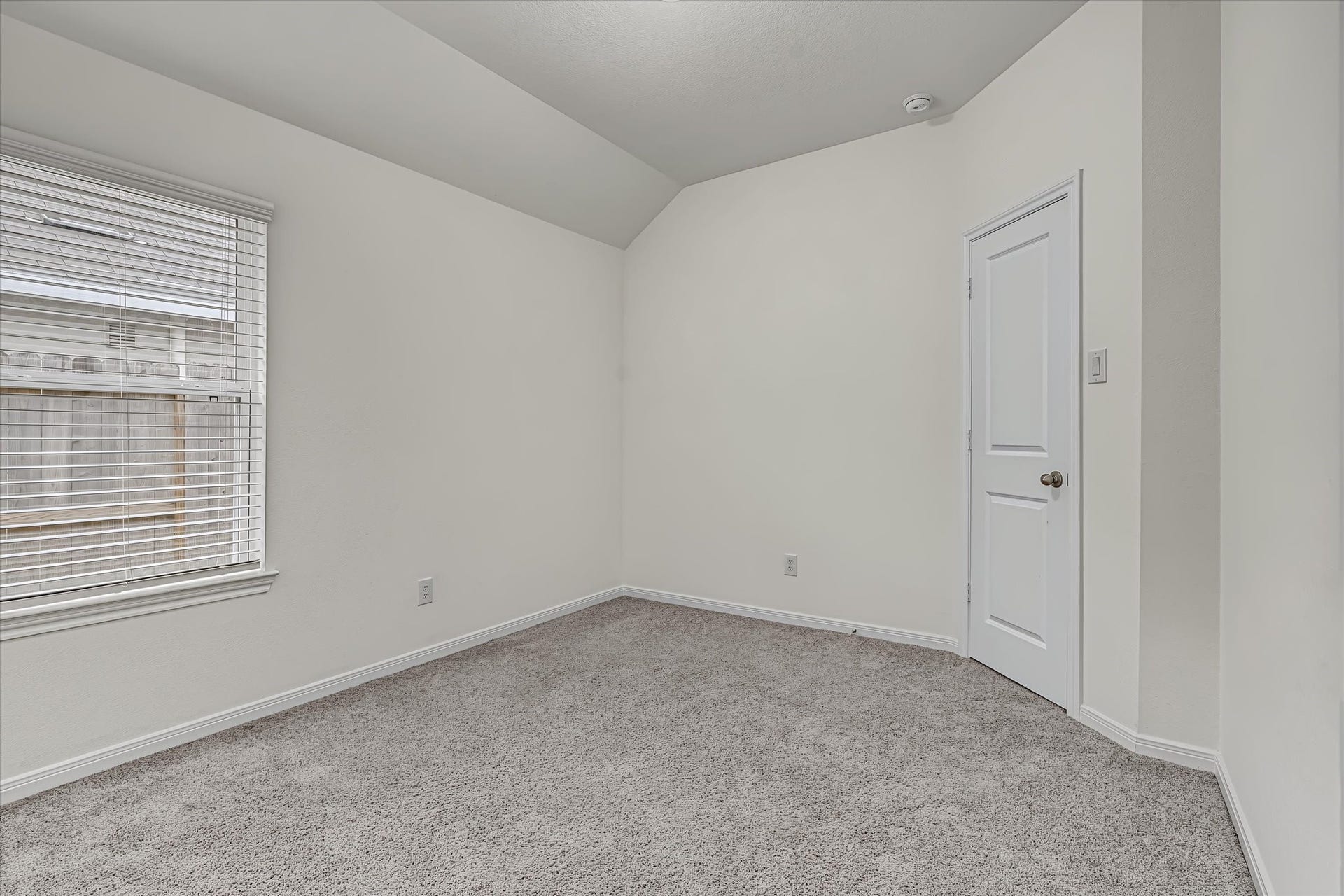 9607 Bright Song Lane, Houston, TX 77078 Bright and cozy 3rd bedroom with soft carpet, a large window for natural light, and a sleek white door, perfect for a bedroom or home office.